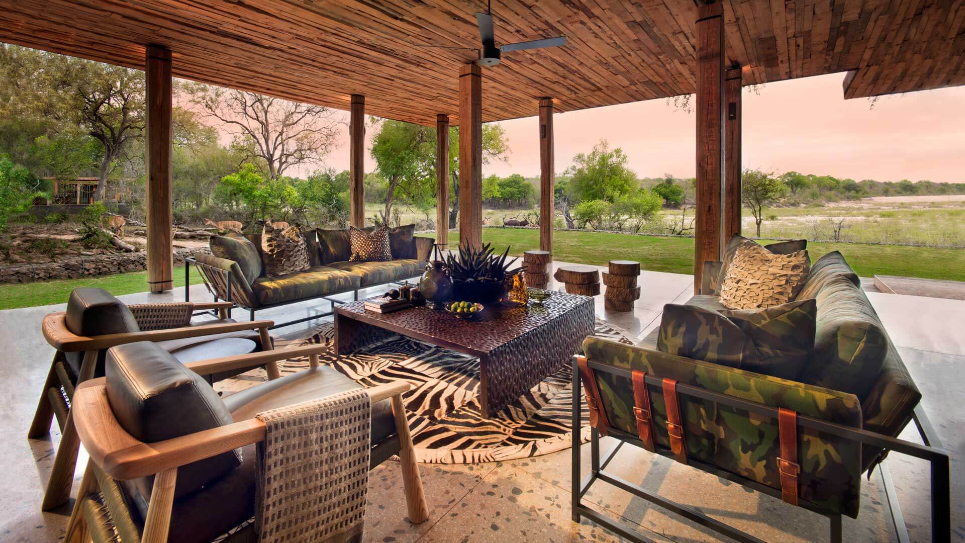 Offene Lounge-Terrasse der Lodge über dem Sand River im Abendlicht