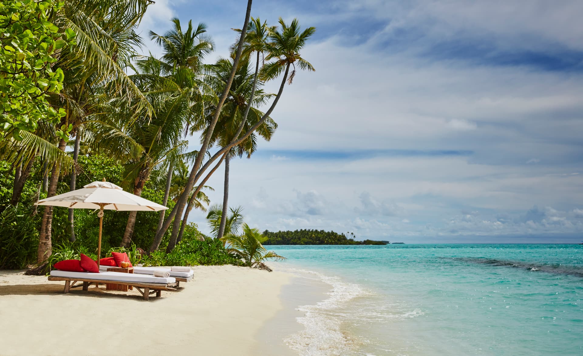 Liegen unter Palmen am Strand von Lavadhoo mit Blick auf das Riff