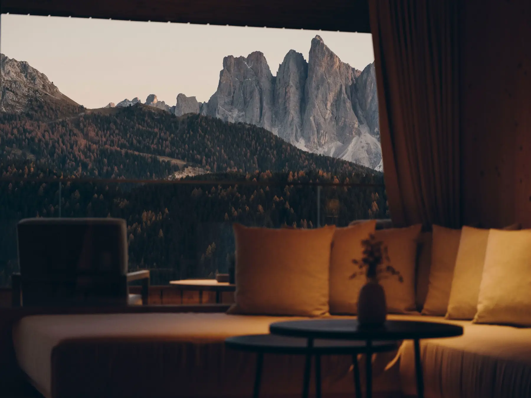 Sitzbank am Panoramafenster mit Leinenkissen und Blick auf die Dolomiten