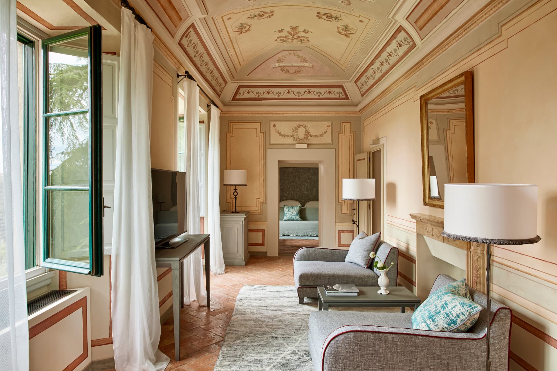 Wohnraum der Heritage Suite mit Freskengewölbe, Kamin und Blick in den Park
