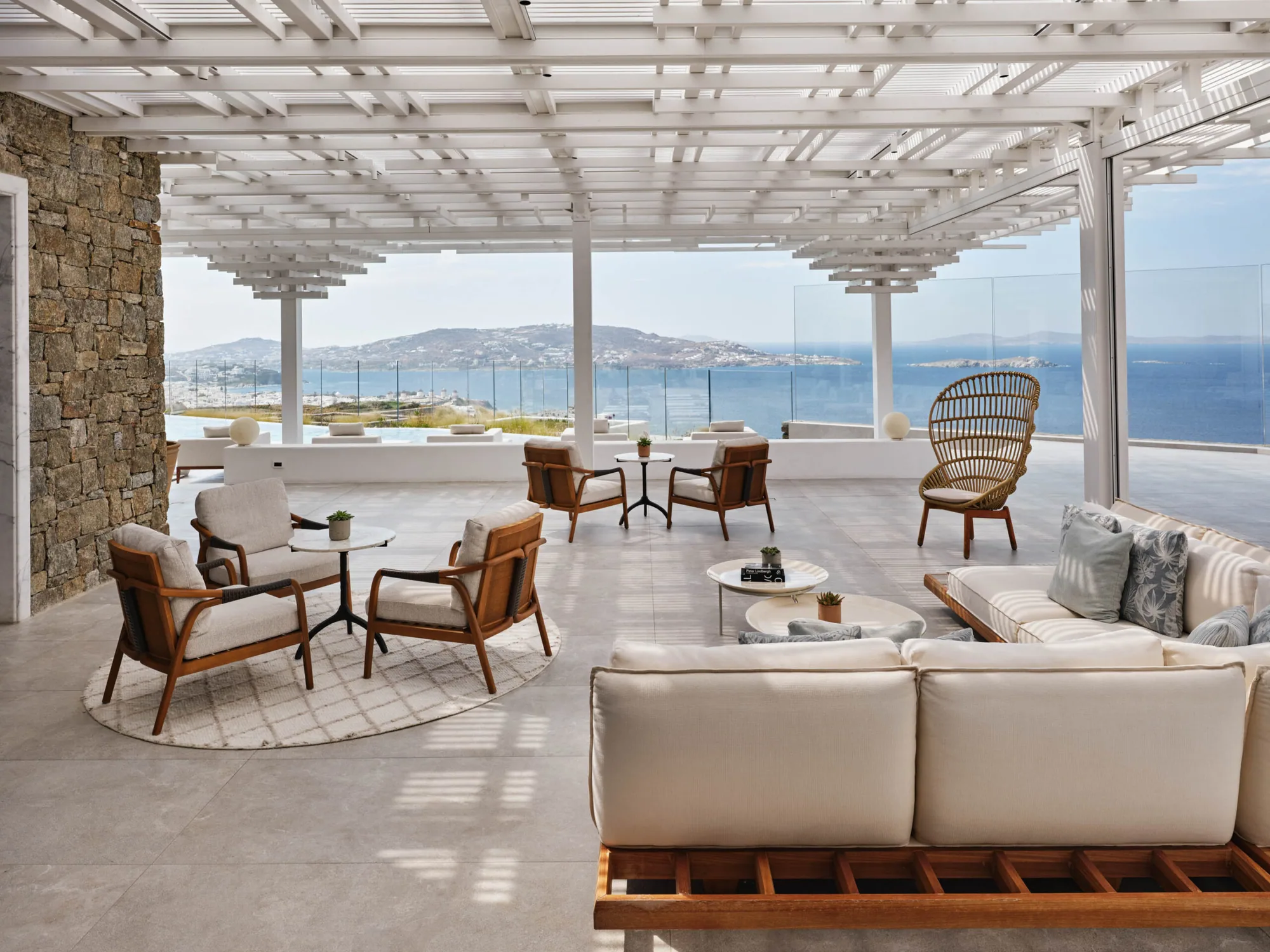 Loungebereich unter Holzpergola mit Blick über die Bucht