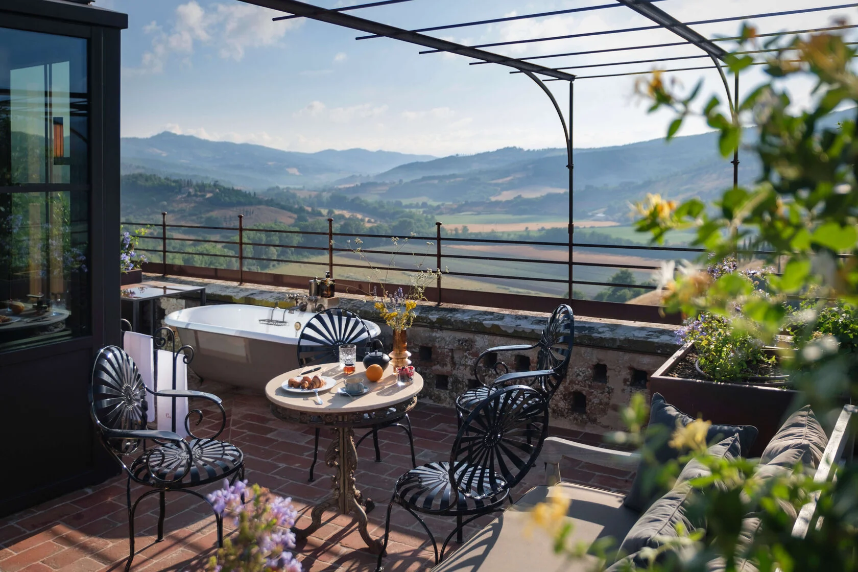 Dachterrasse mit freistehender Wanne, Frühstückstisch und Blick über das Tal