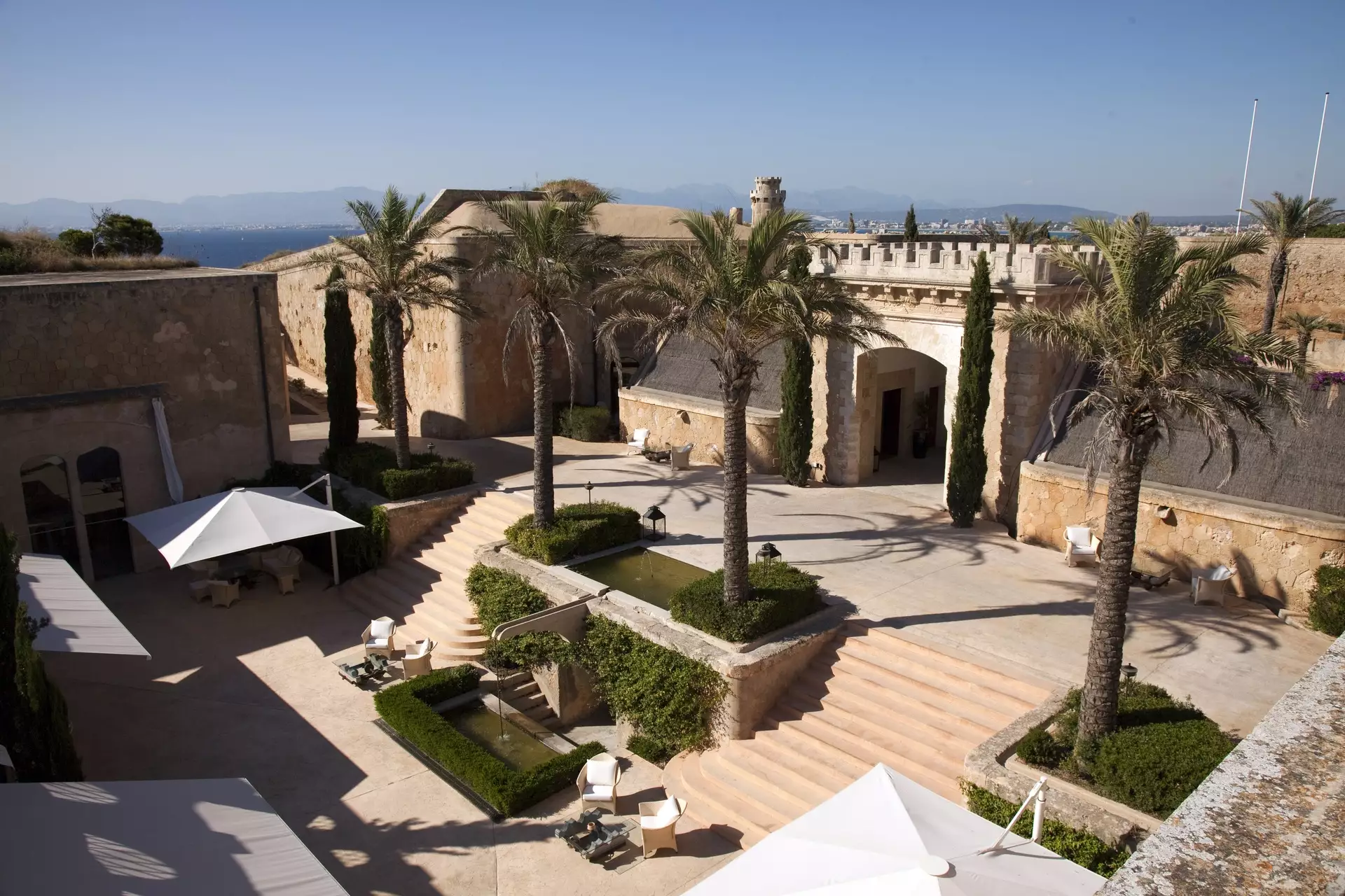 Innenhof der Festung Cap Rocat mit Palmen, Wasserbecken und Blick über die Bucht von Palma