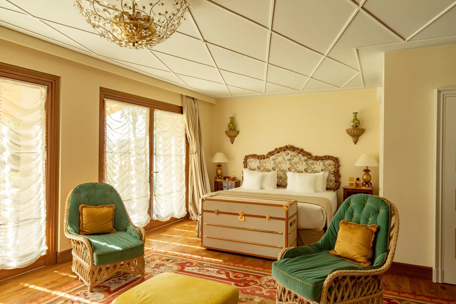 Zimmer mit grünen Sesseln, hohen Fenstern und Blick in den Garten