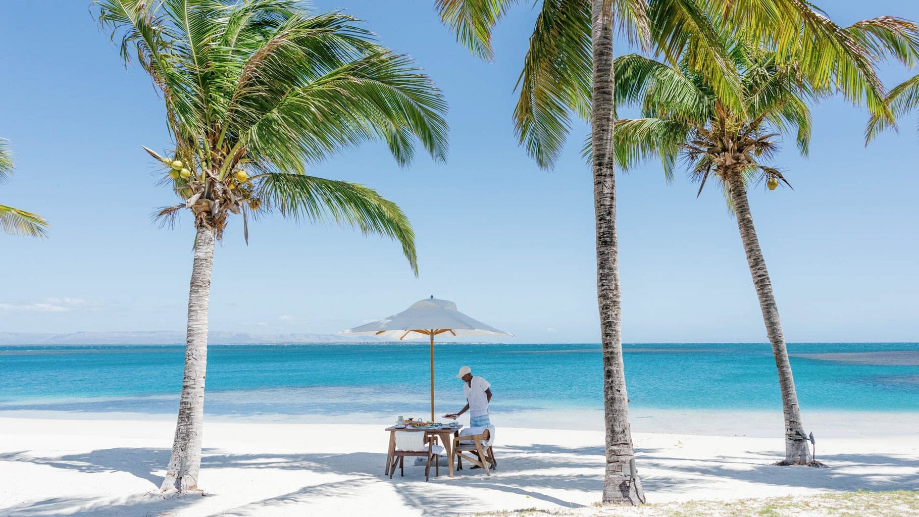 Frühstück am Strand mit gedecktem Tisch im Sand