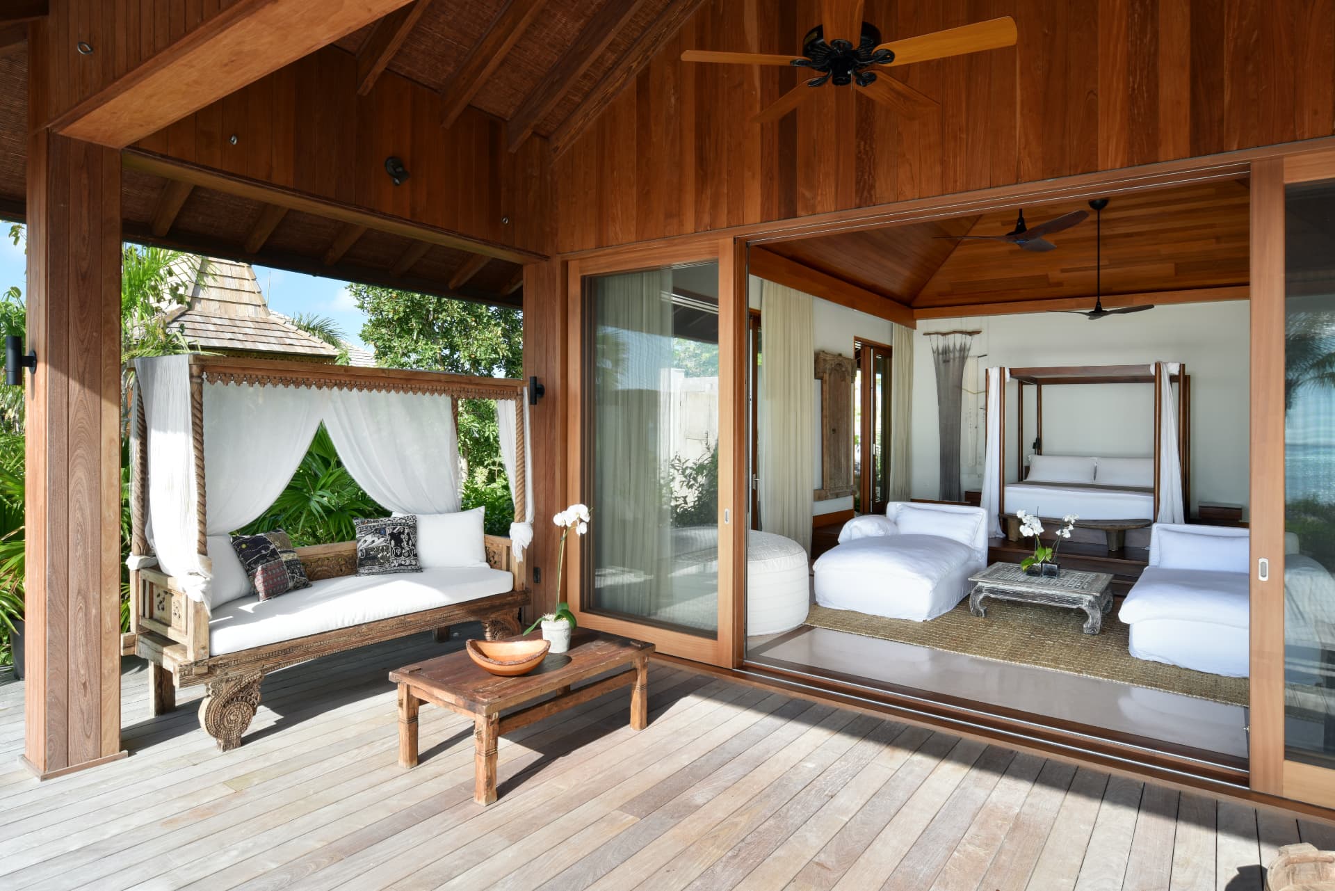 Schlafbereich der Villa Love Pumpkin mit Deck, Daybed und Himmelbett hinter Schiebetüren