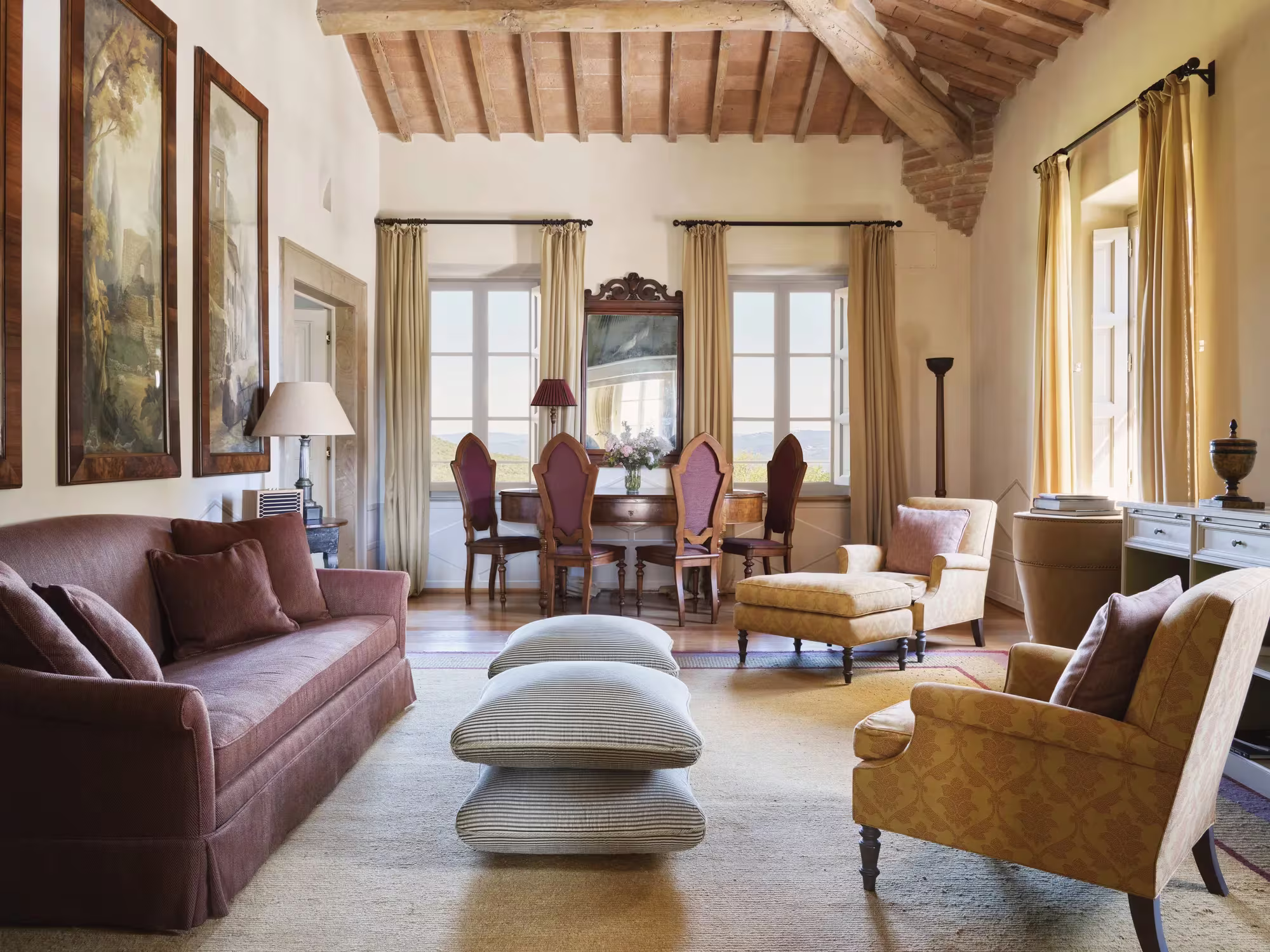 Schlafzimmer einer Borgo Suite in Castiglion del Bosco mit Leinenbettwäsche, warmem Holz und Blick in die toskanische Landschaft