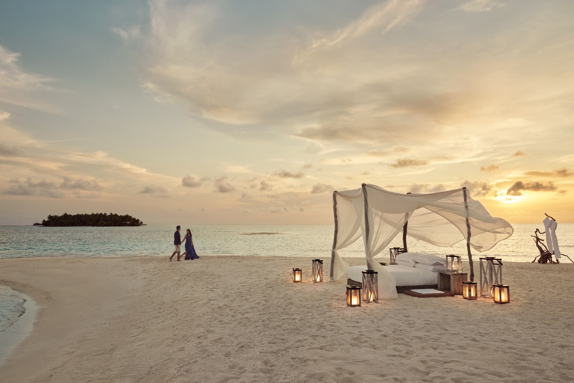 Bett mit Laternen auf der Sandbank Lavadhoo im Abendlicht