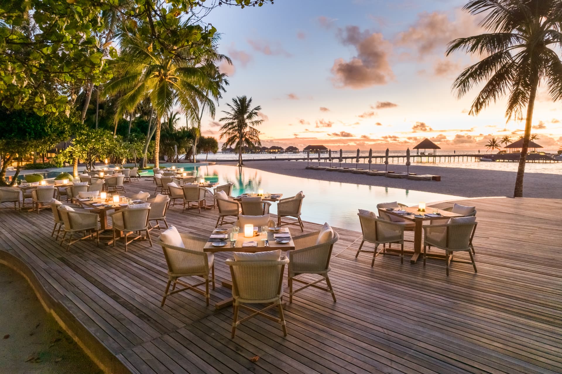 Gedeckte Tische am Pool des Restaurants Madi im Abendlicht