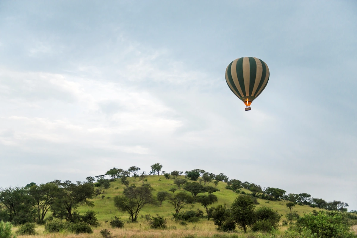 Heissluftballon über den bewaldeten Hügeln des Grumeti-Reservats