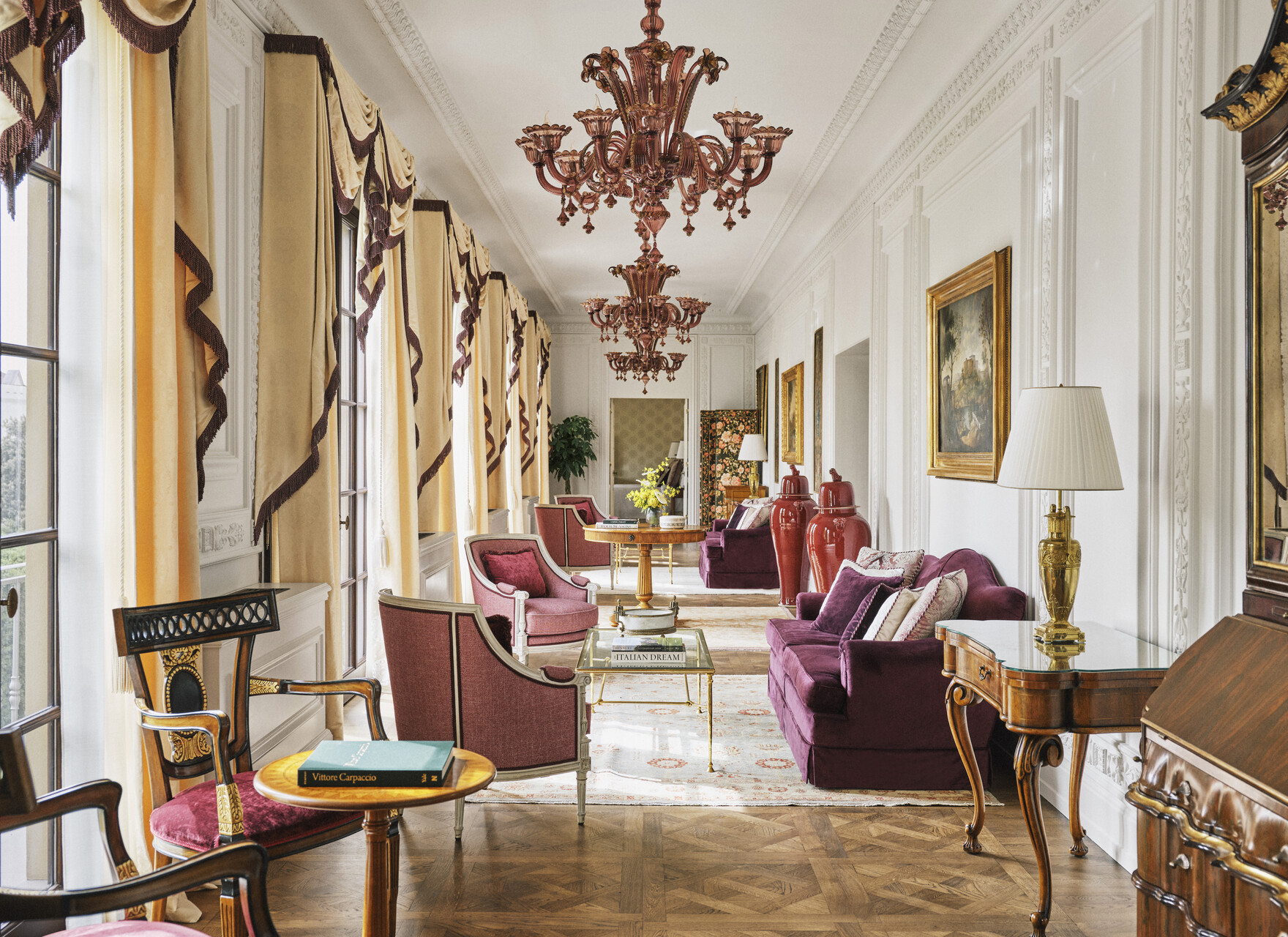 Lange Salongalerie mit Muranoleuchtern, Parkett und Blick in den Park