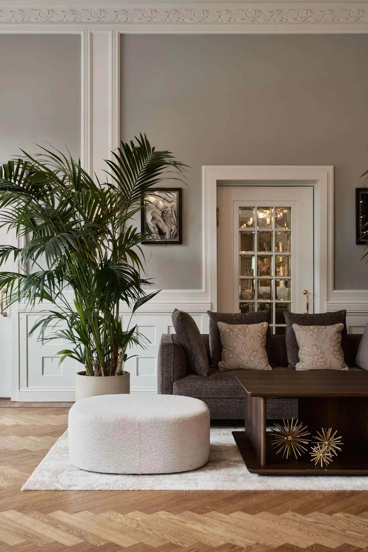 Salon mit Fischgrätparkett, Sofa und hoher Kassettendecke