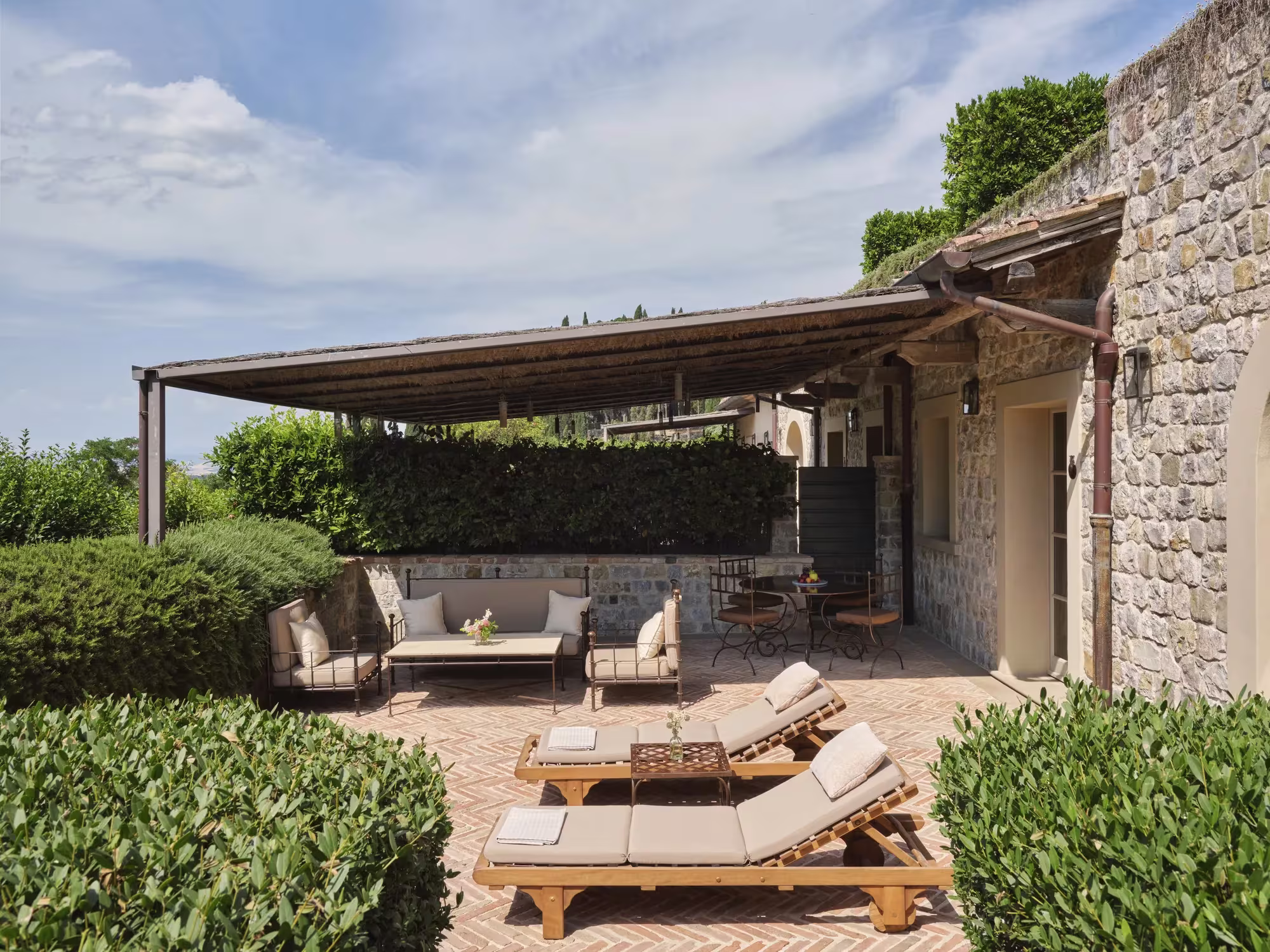 Wohnraum der Terrace Suite in Castiglion del Bosco mit Kamin, Holzbalken und Blick auf die Terrasse
