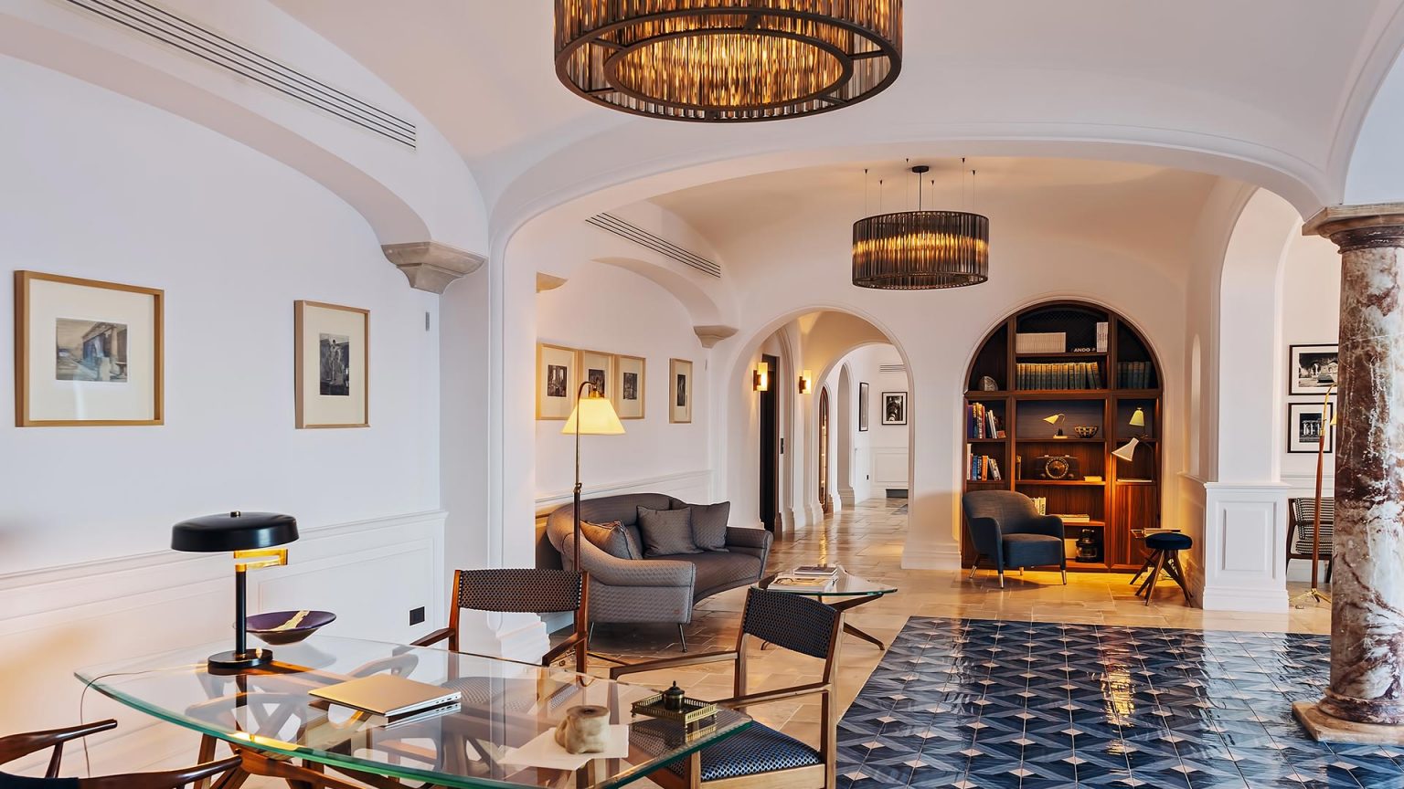 Gewölbte Lobby des Borgo Santandrea mit Bibliothek, Rattanmöbeln und blauen Zementfliesen