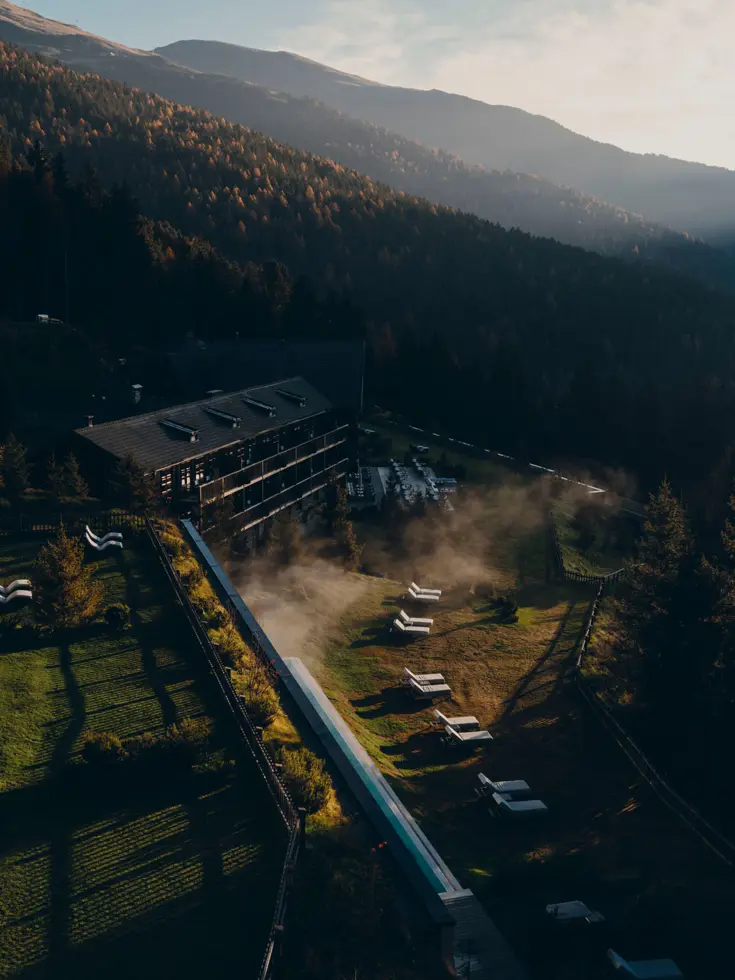Das Haus am Waldhang über Brixen von oben, Nebel über dem Pool im Morgenlicht