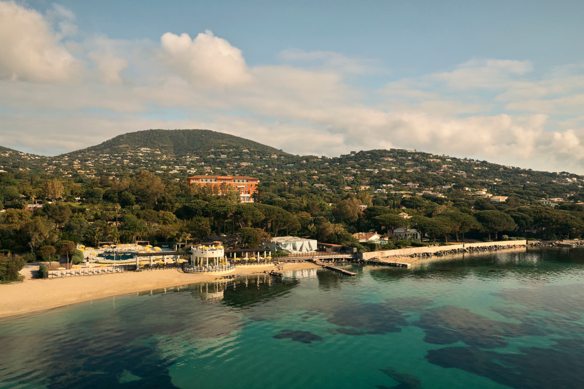 Das Haus über der Bucht: Strand, Pool und türkises Wasser aus der Luft