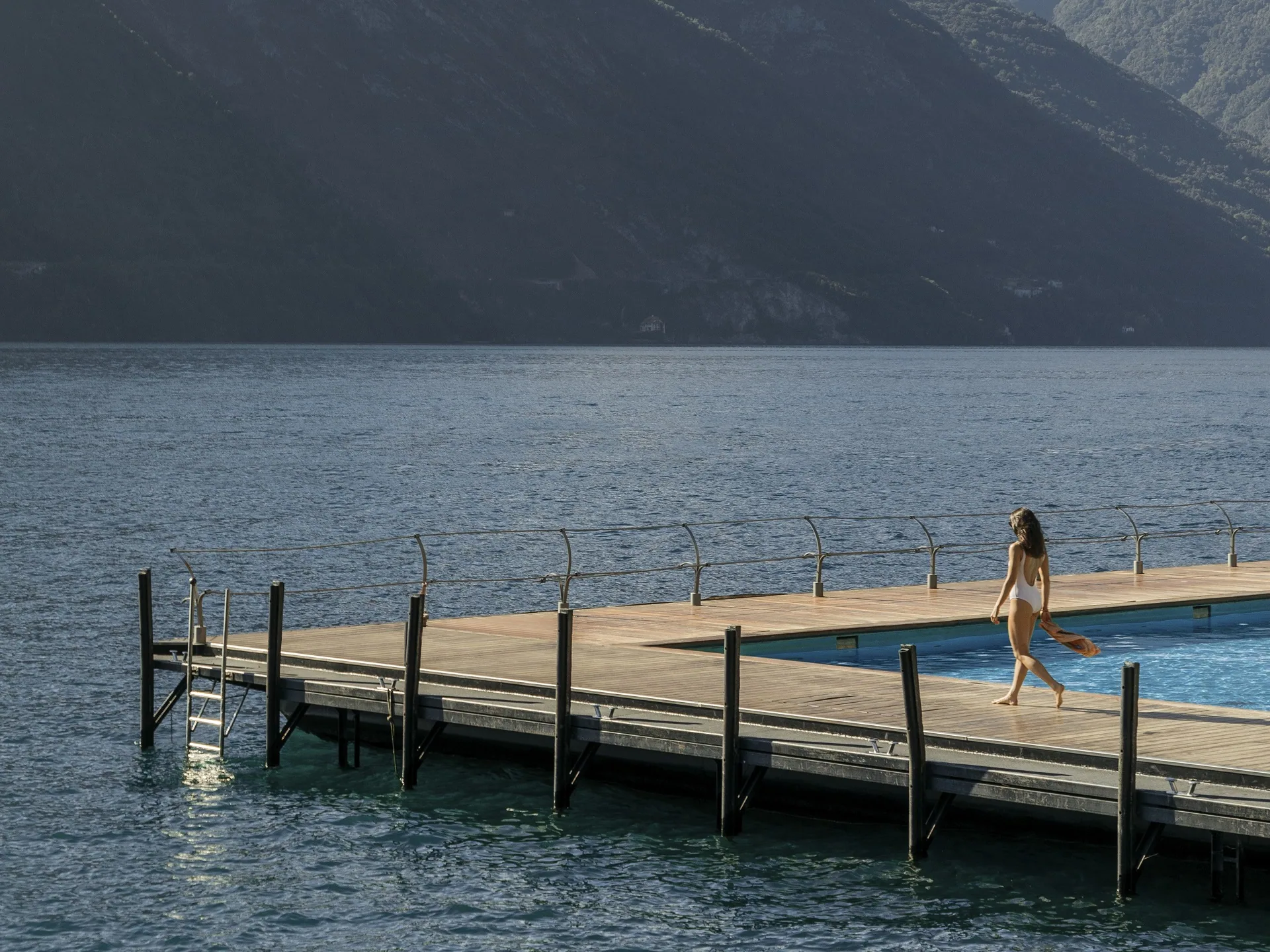 Schwimmender Pool des Grand Hotel Tremezzo auf dem Comer See, dahinter die Berge