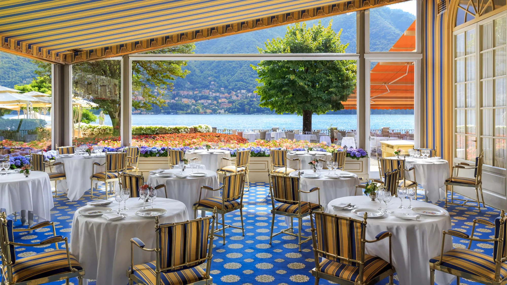 Restaurant Veranda der Villa d'Este mit gedeckten Tischen vor der Fensterfront zum See