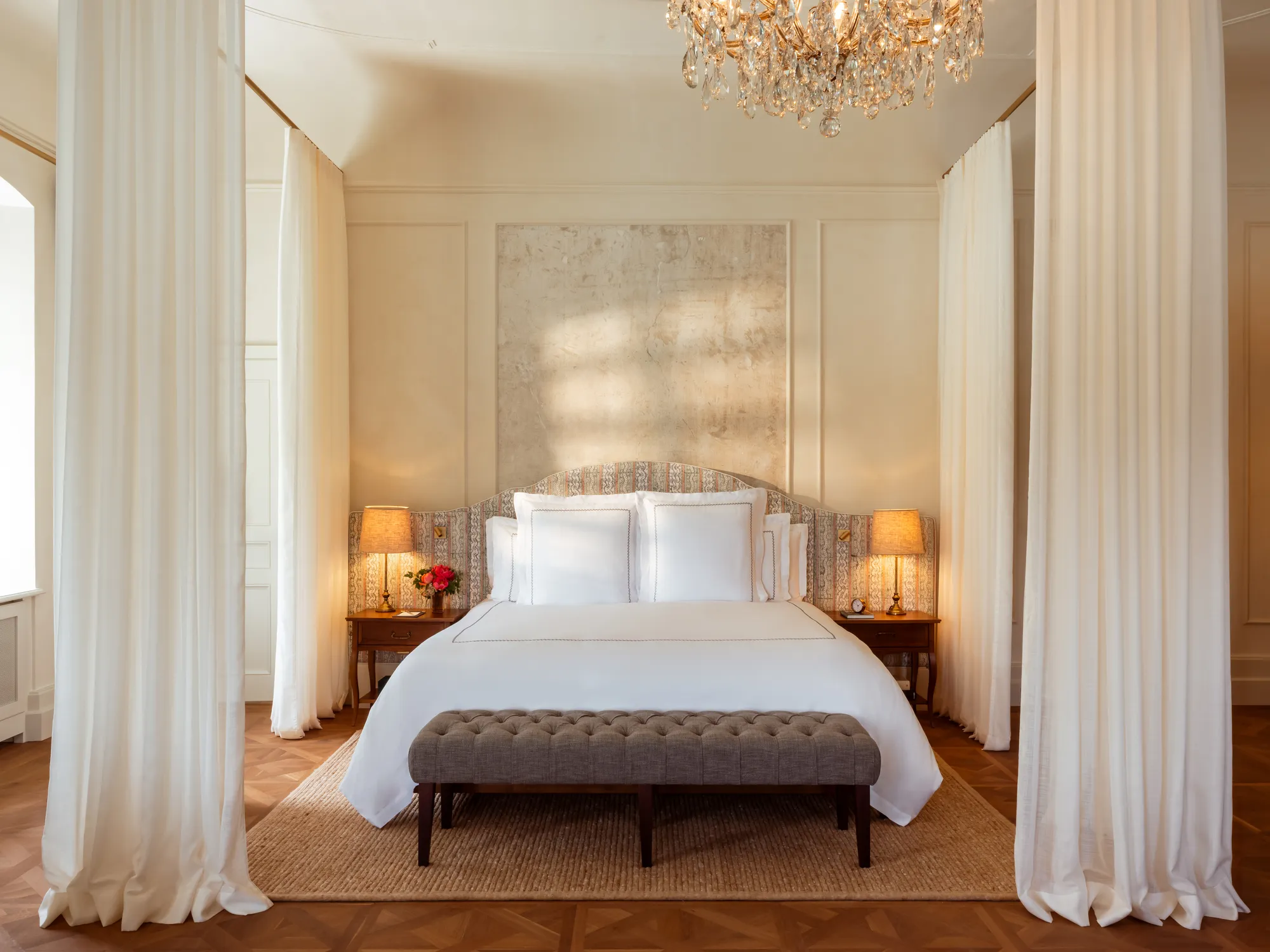 Schlafzimmer einer Heritage Suite im Rosewood Schloss Fuschl mit Himmelbett, Kristalllüster und Fischgrätparkett