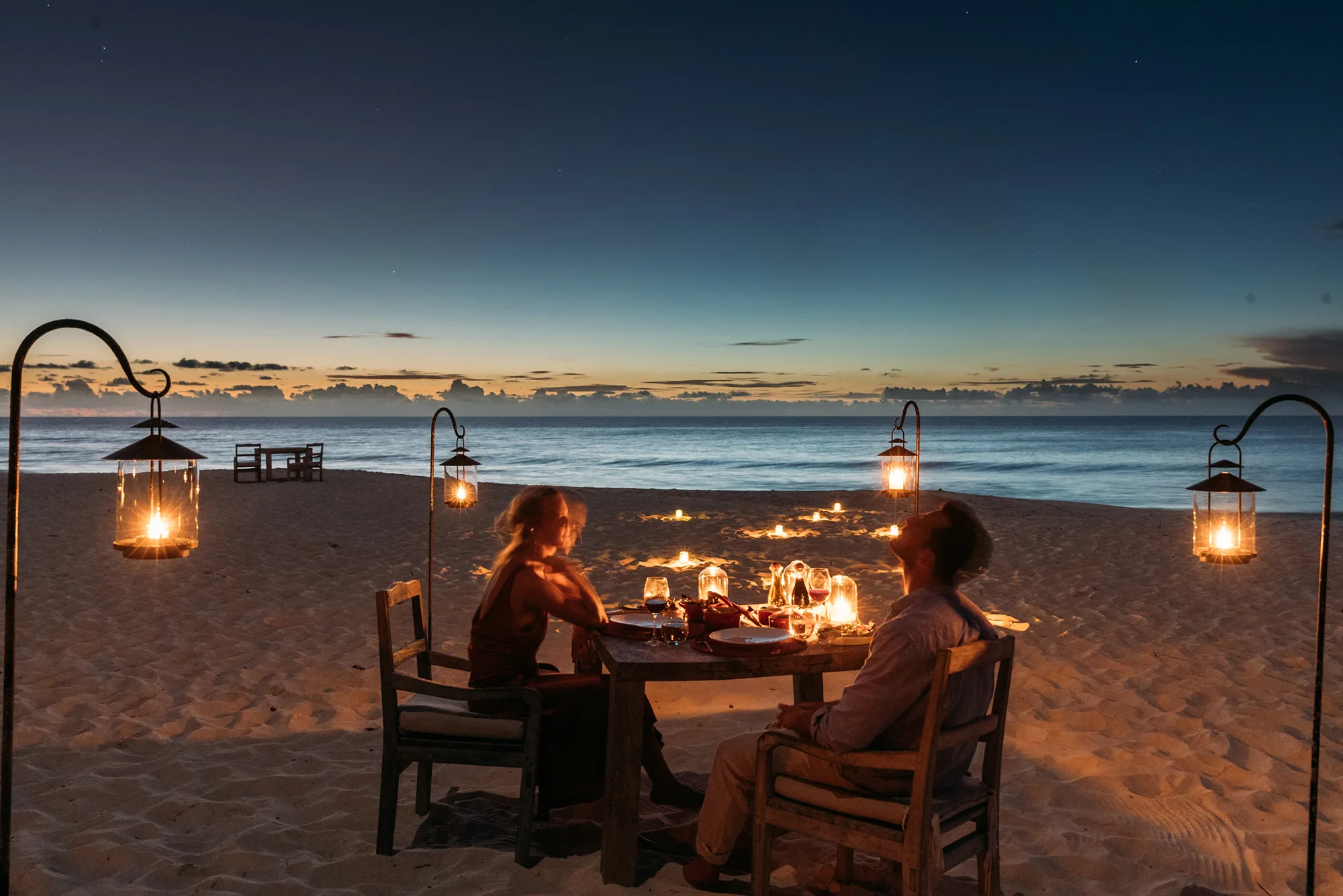 Gedeckter Tisch am Strand bei Sonnenuntergang