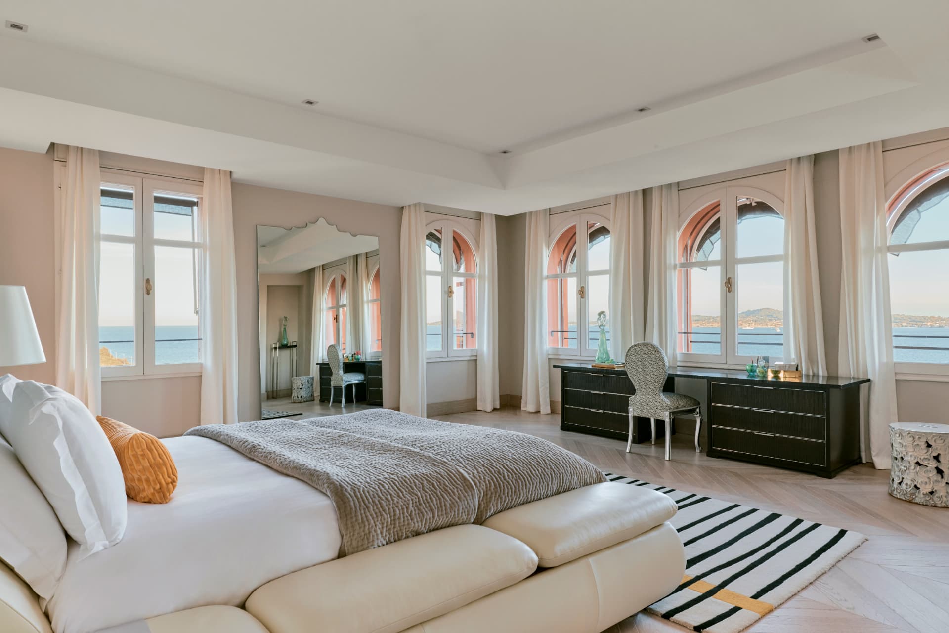 Schlafraum der COMO Suite mit Bogenfenstern zum Meer