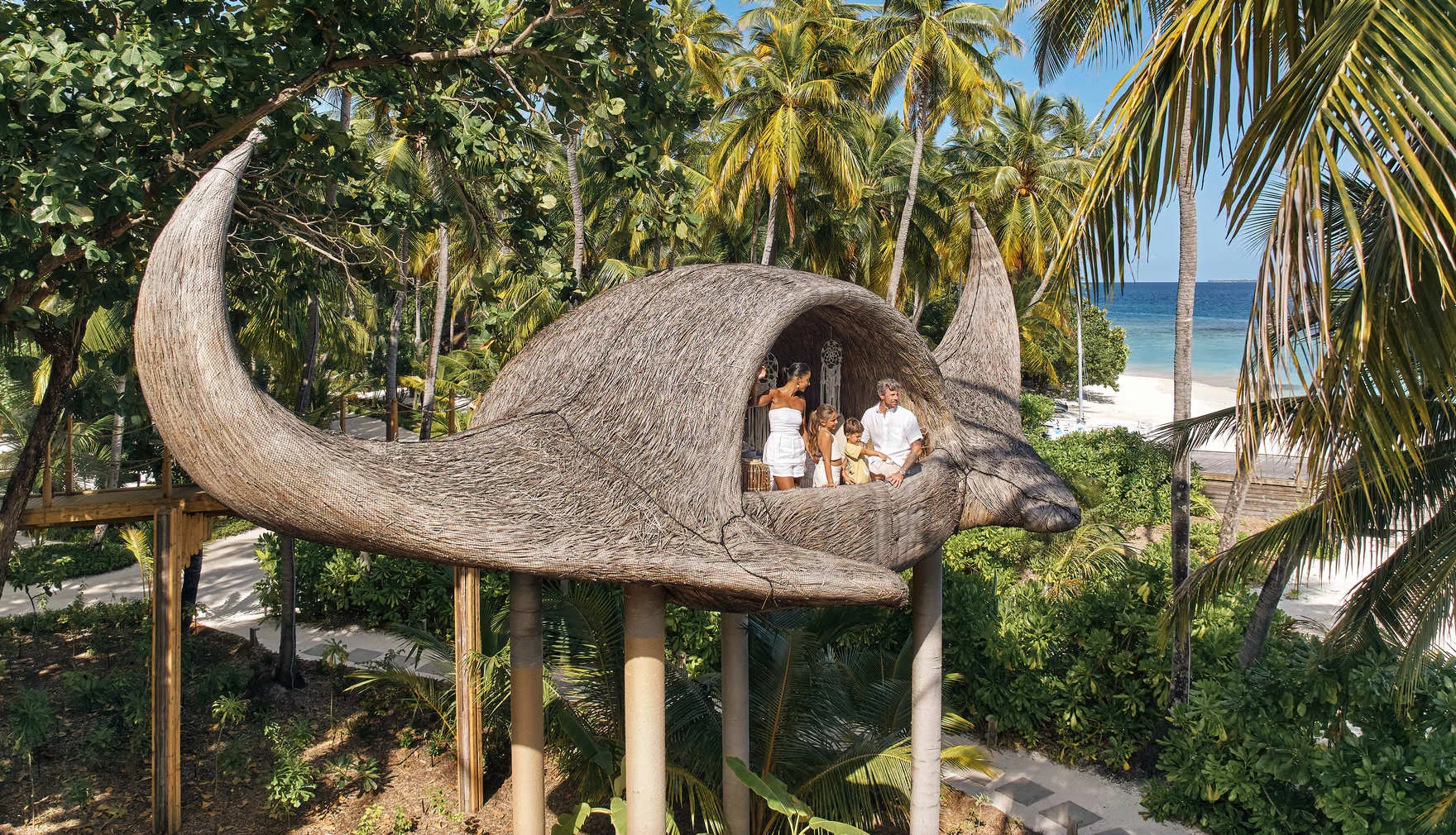 Das Manta-Baumhaus von JOALI Maldives zwischen Palmen über dem Strand