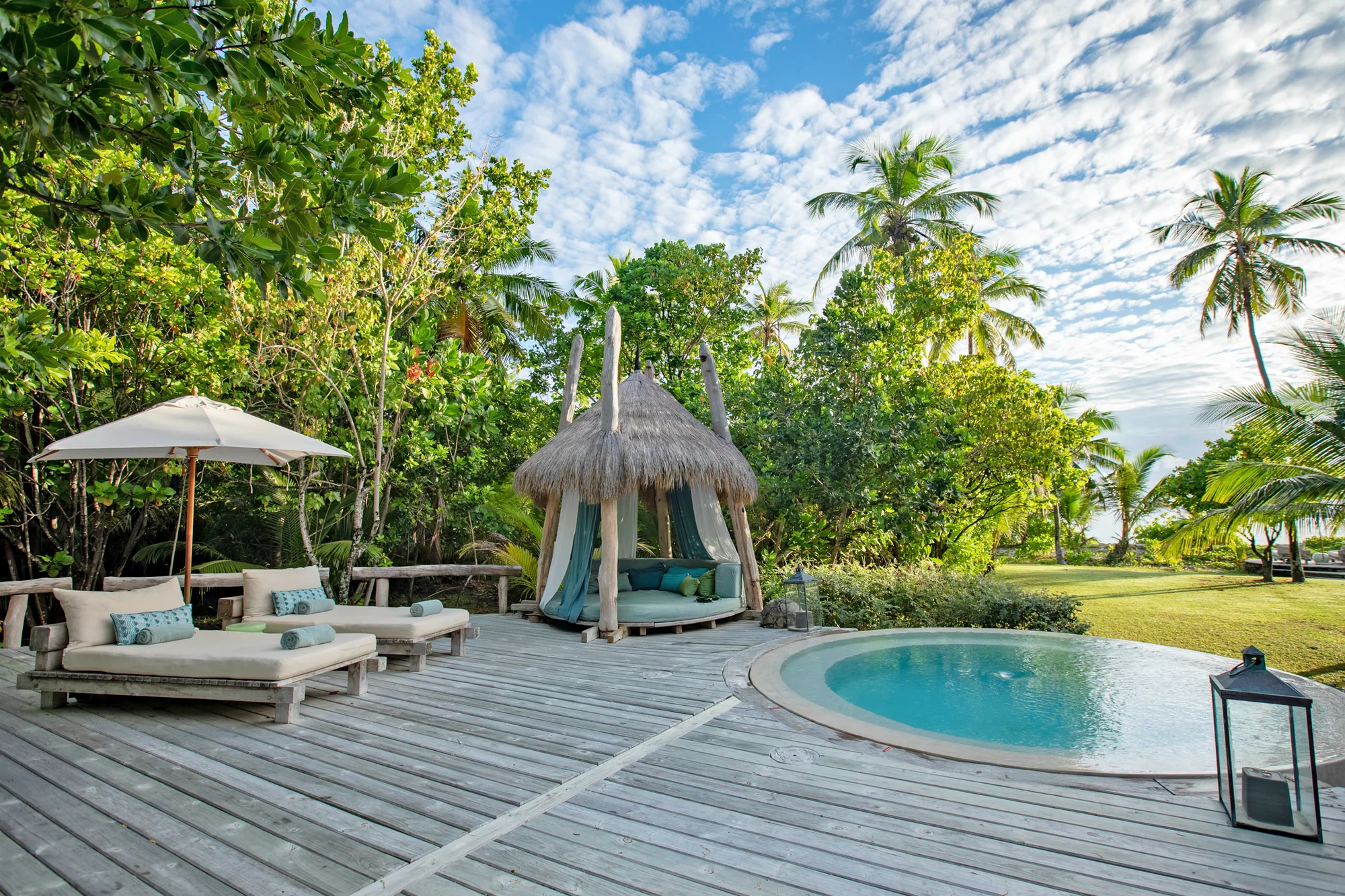 Sala und Pool einer Beachfront Villa unter Palmen