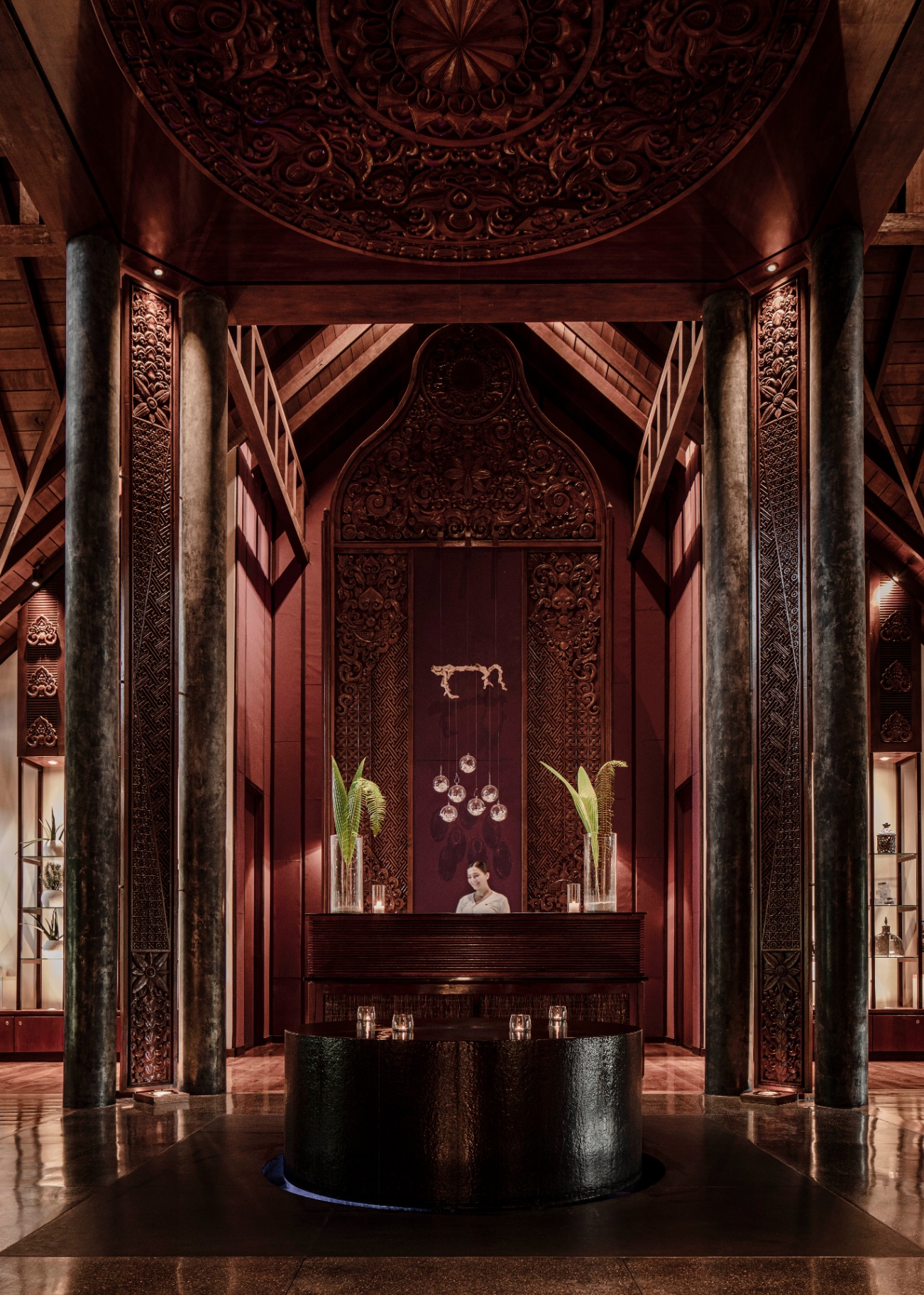 Empfang des One&Only Spa mit hoher, kunstvoll geschnitzter Holzdecke, Steinsäulen und warmem, gedämpftem Licht