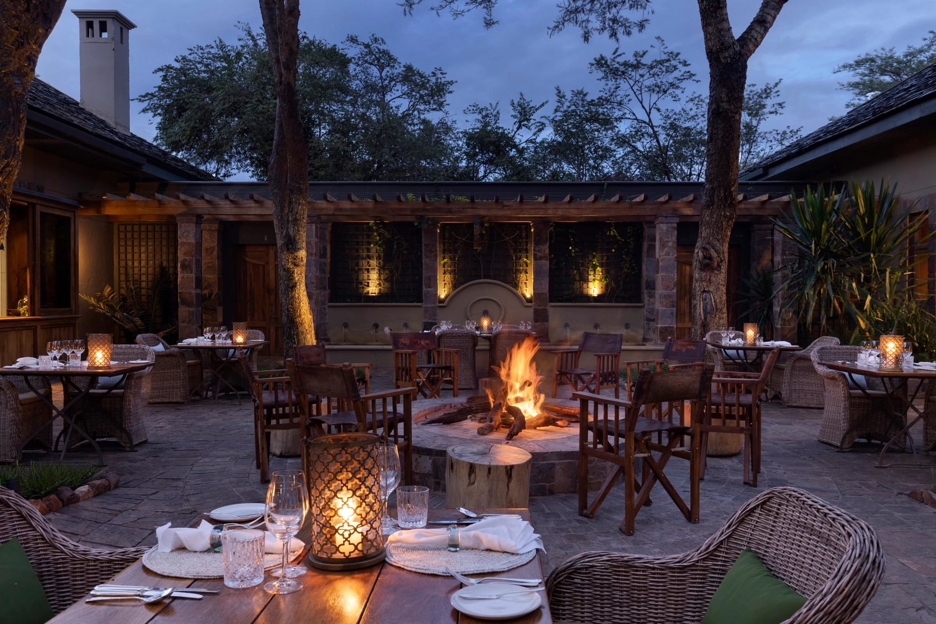 Abendessen im Innenhof der Sasakwa Lodge um das offene Feuer, Laternen auf den Tischen