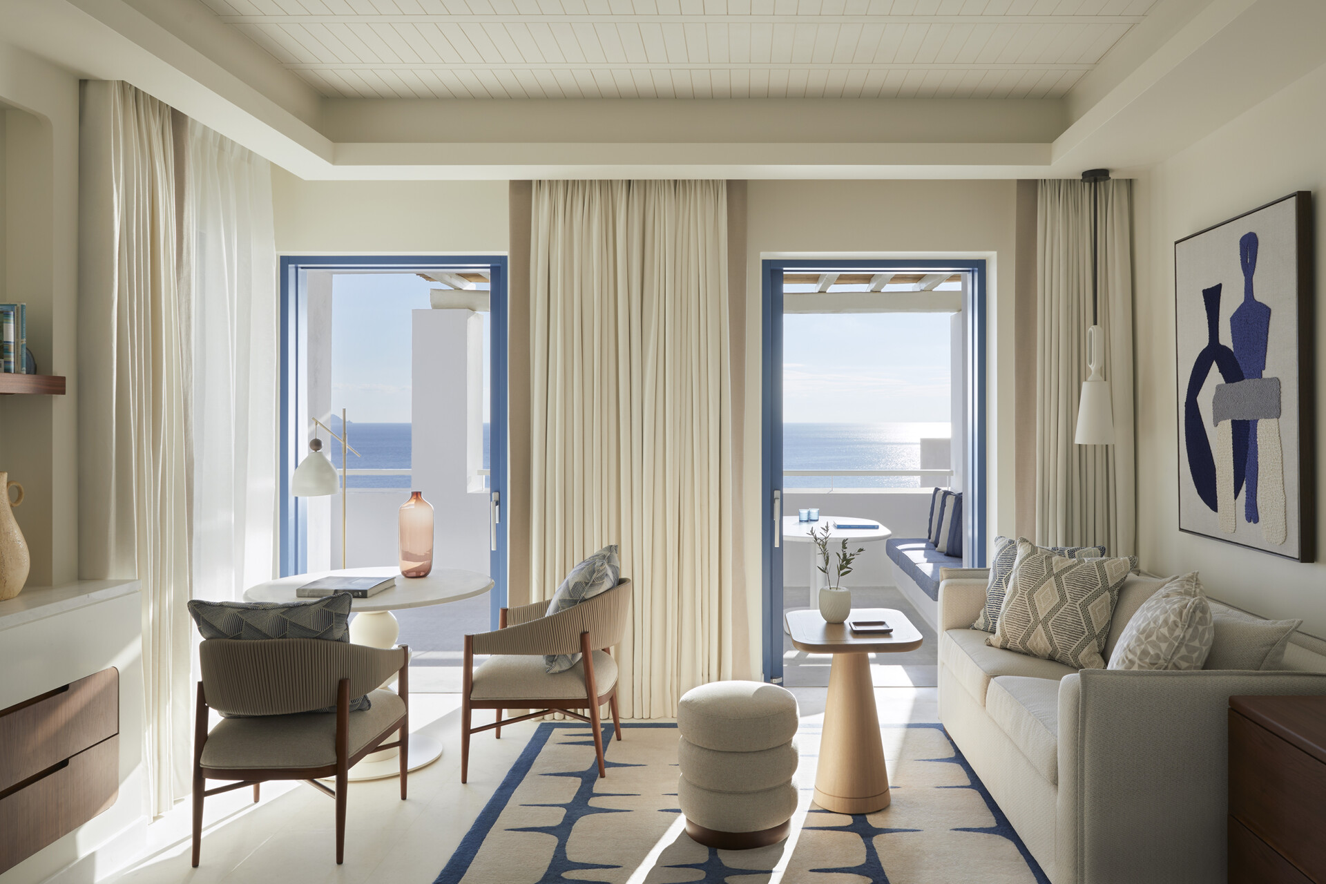 Wohnbereich mit zwei offenen Türen zur Terrasse und Blick auf das Meer