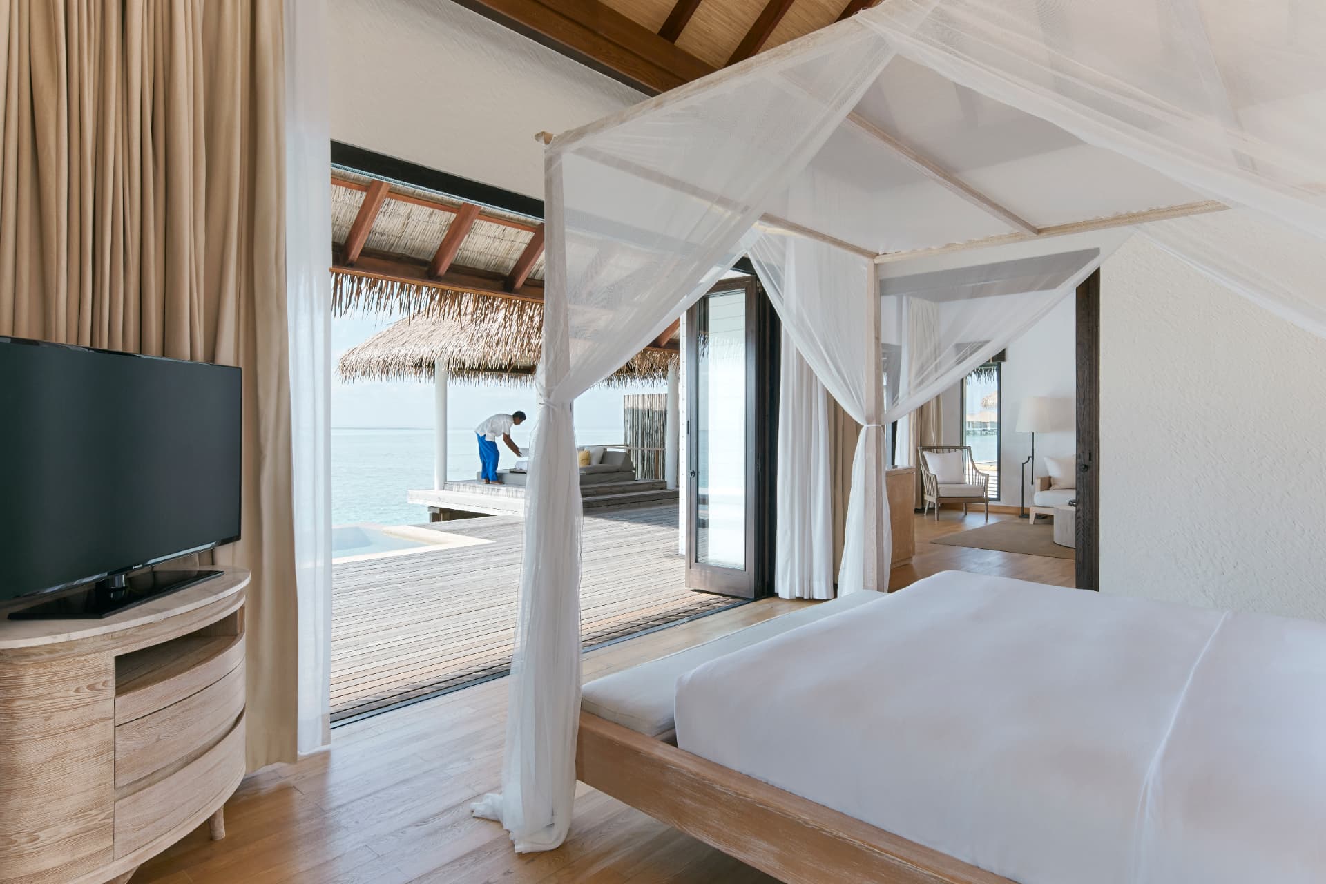 Wasservilla-Schlafzimmer mit Himmelbett und Blick auf die Lagune