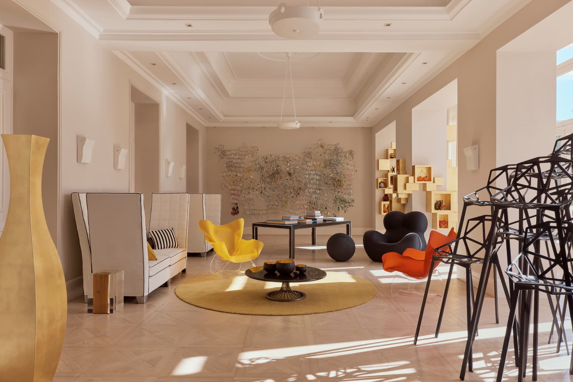 Lobby mit Parkettboden, Kunstobjekten und hohen Fenstern