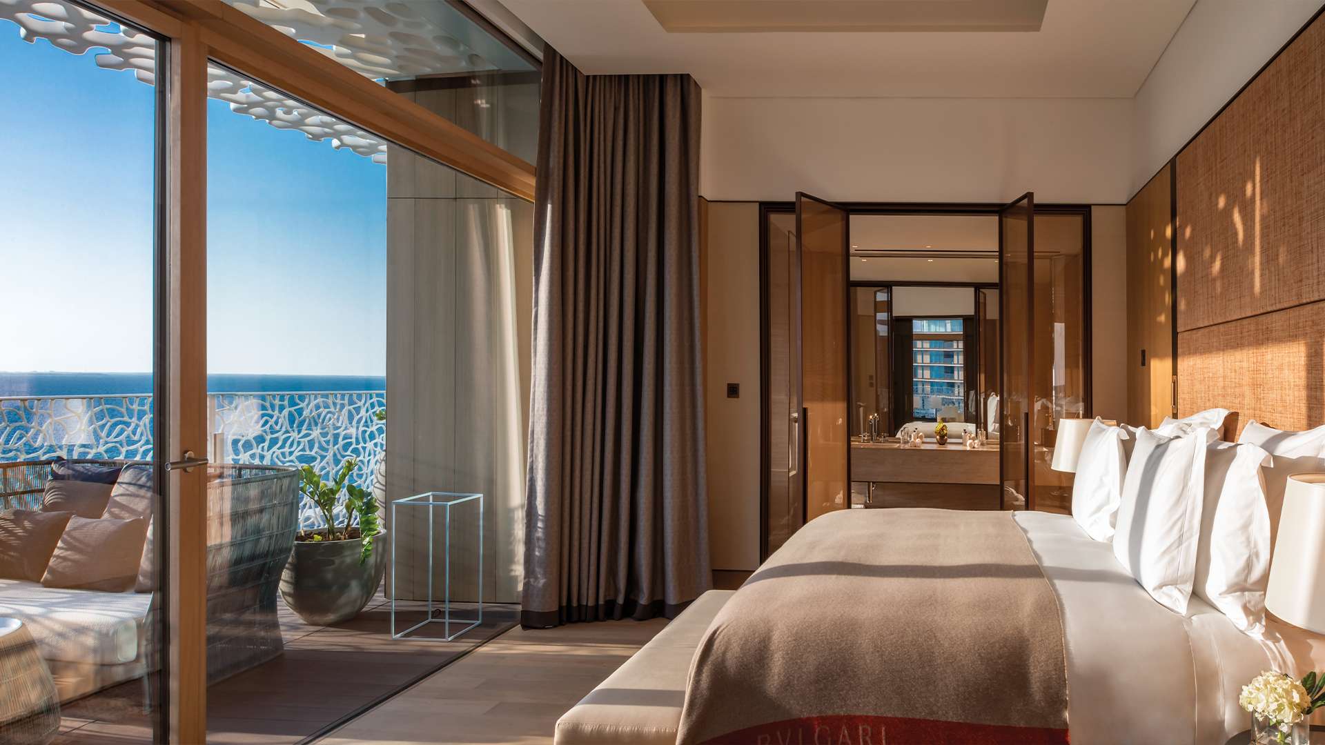 Schlafzimmer einer Suite mit geöffneter Front zur Terrasse über dem Golf