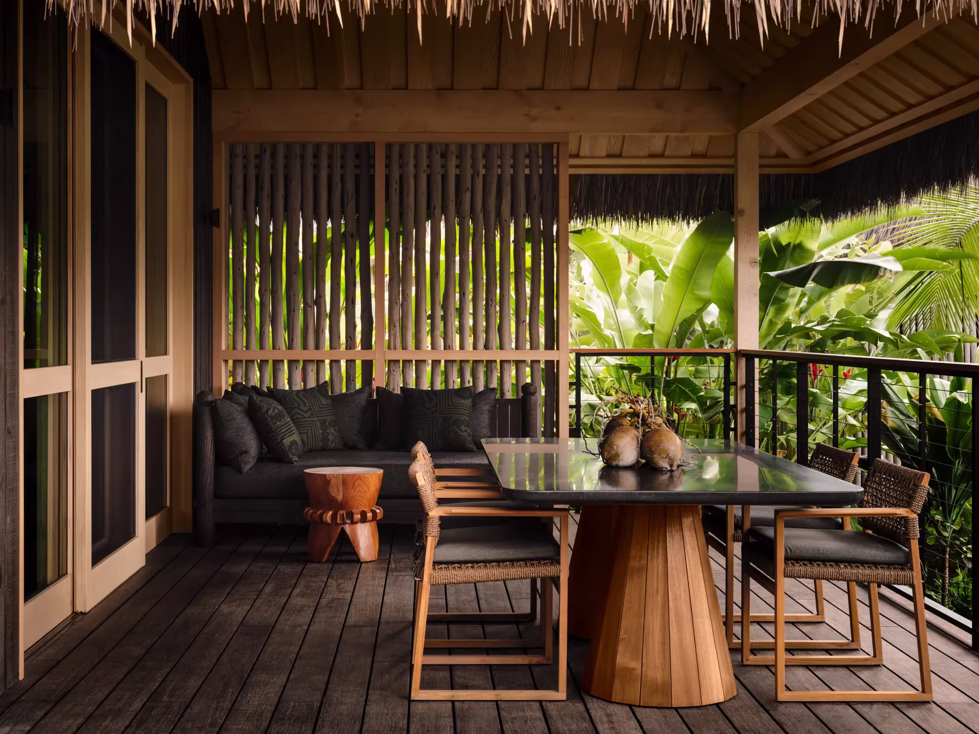 Lanai eines Lagoon View Hale im Rosewood Kona Village mit Sitzgruppe und Blick über das stille Wasser