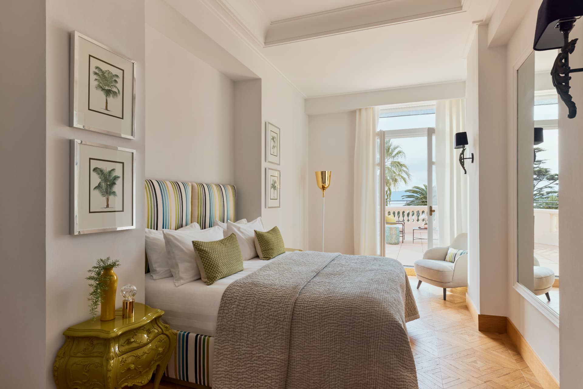 Schlafraum der Two Bedroom Suite mit Palmendrucken und Tür zur Terrasse