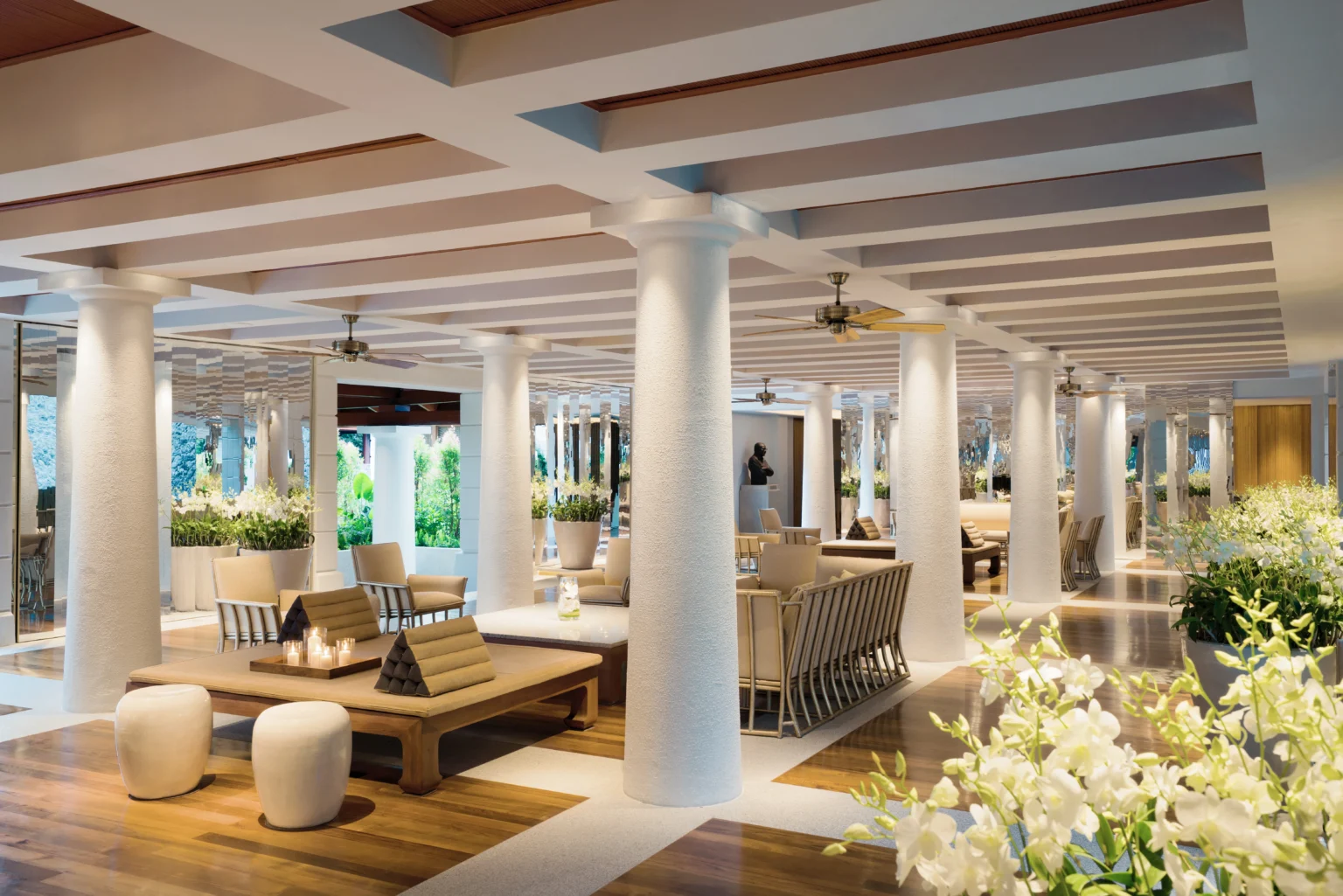Orchid Lounge mit weissen Säulen, Thai-Bänken und Orchideen