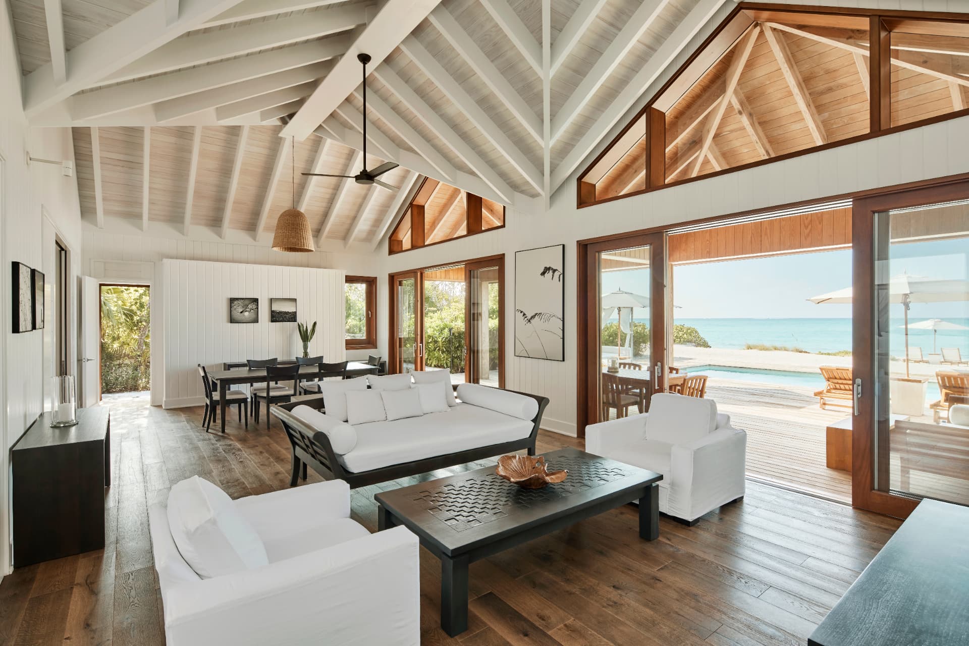 Wohnraum des Two Bedroom Beach House mit offenem Dachstuhl und Blick auf Pool und Meer