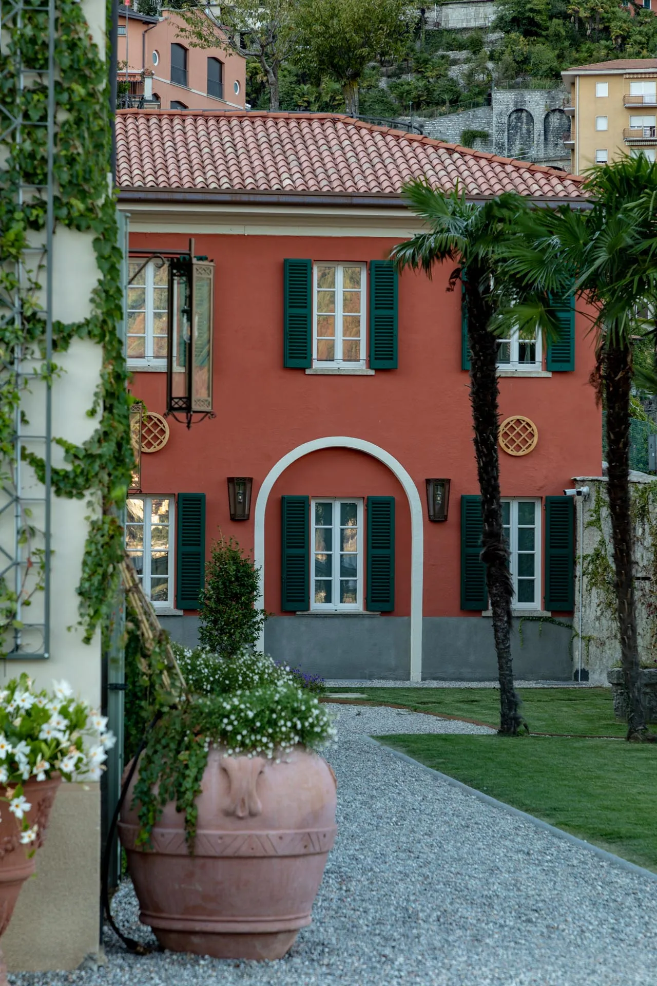 Rosafarbene Fassade der Villa Passalacqua mit Glyzinien und Terrakottatöpfen