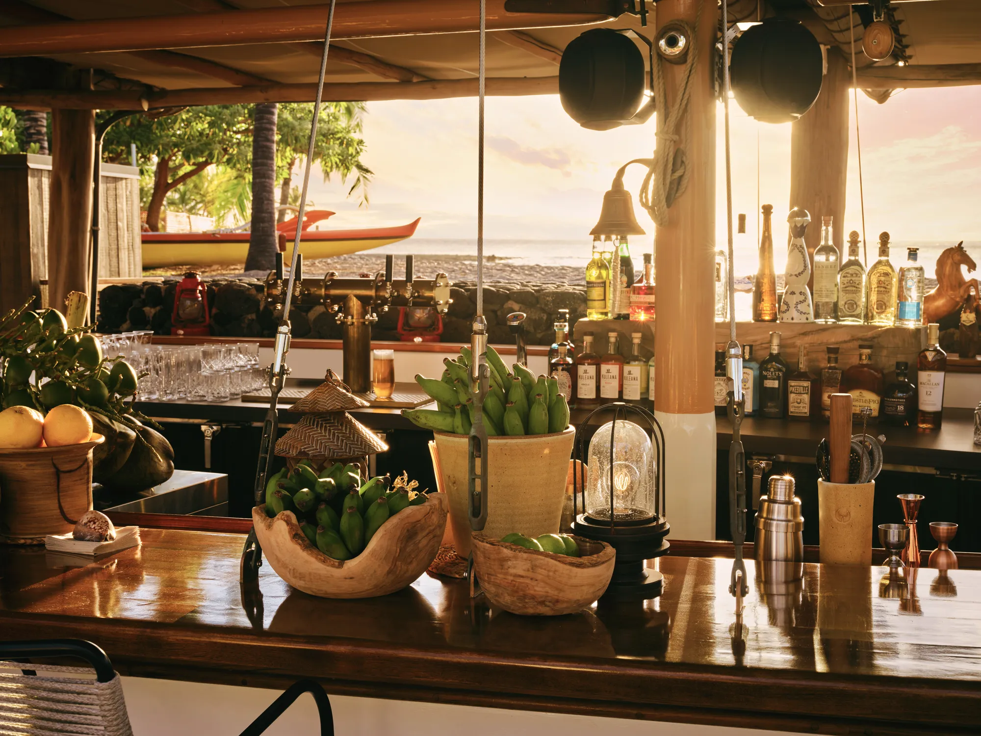 Shipwreck Bar im Rosewood Kona Village bei Sonnenuntergang mit Blick auf Auslegerkanu und Meer