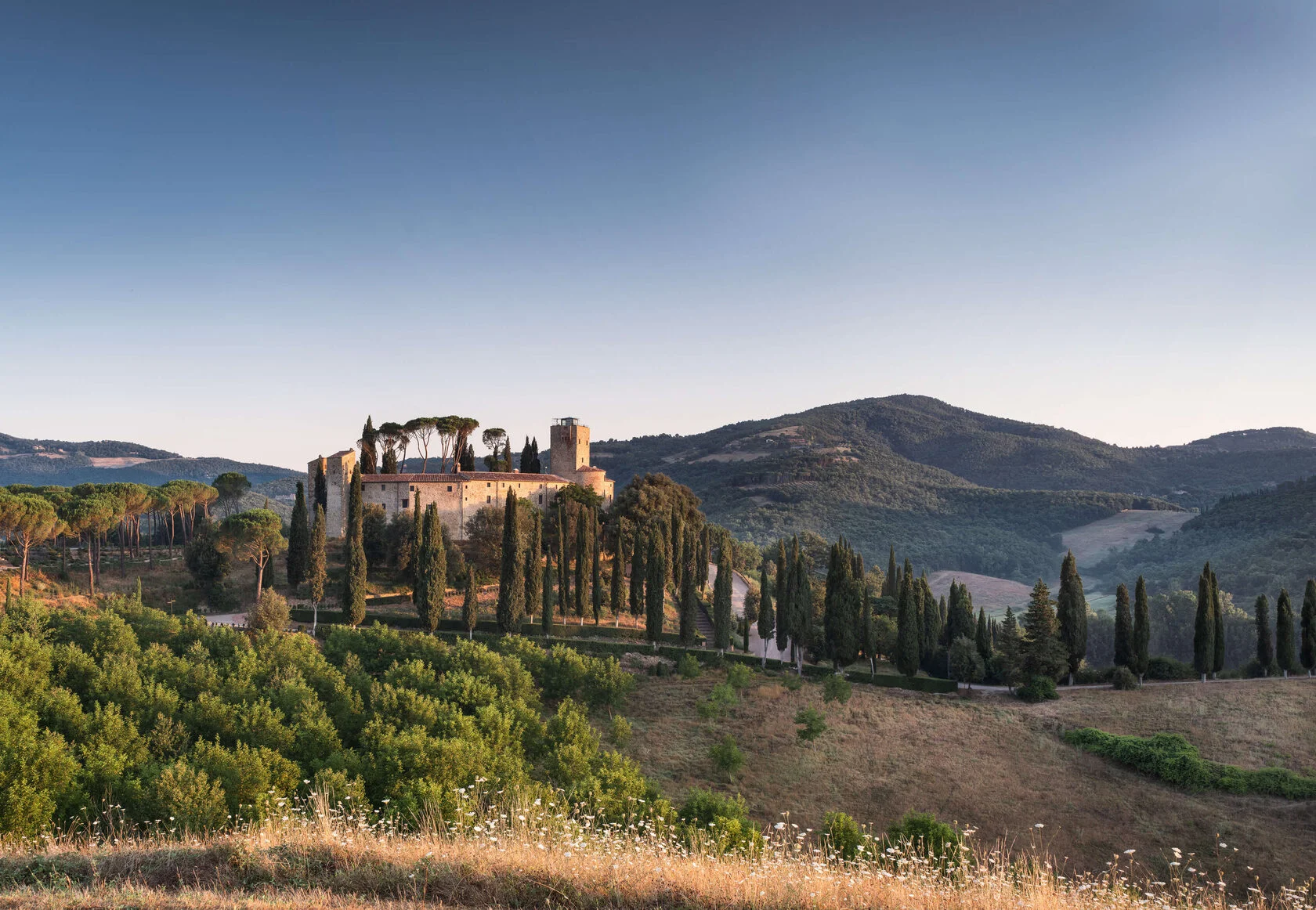 Castello di Reschio auf seinem Hügel über Zypressen und den Hügeln Umbriens