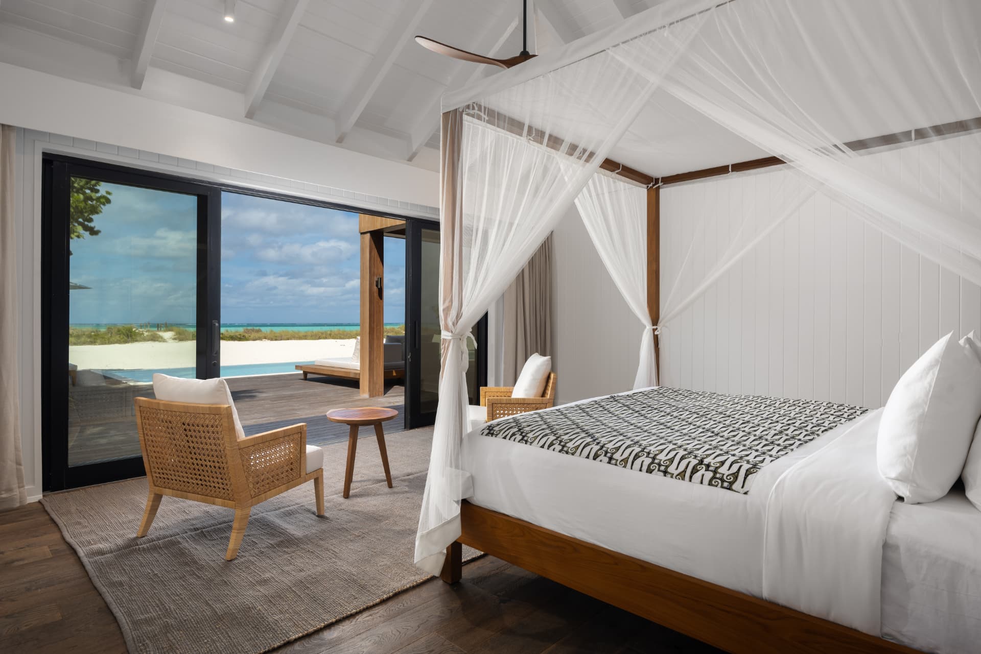 Gästezimmer der COMO Villa mit Himmelbett und offenen Türen zum Deck