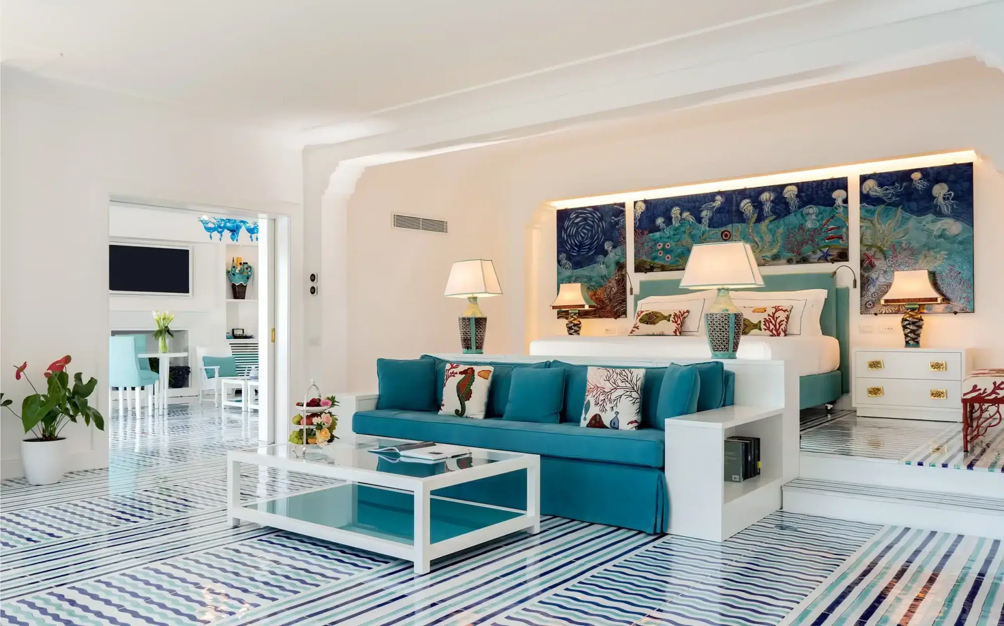 Wohnraum einer Suite mit hellen Sofas und Fenstern zur Amalfiküste