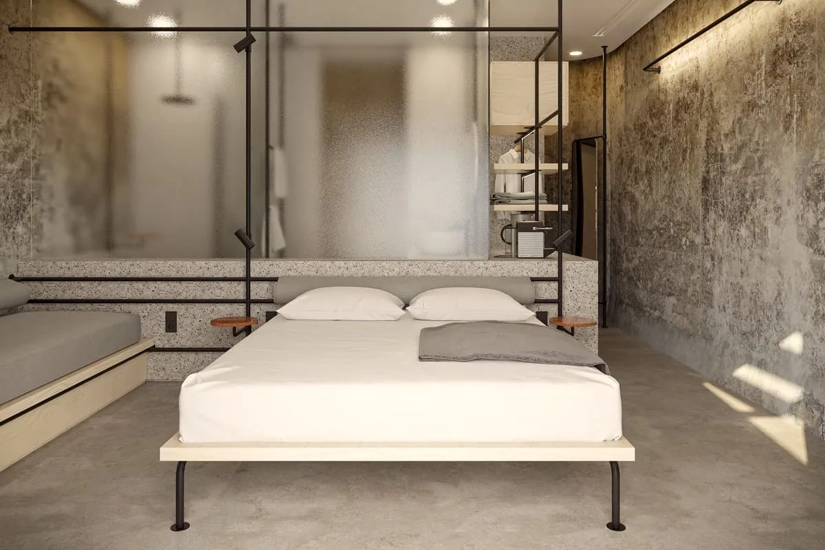 Zimmer in einem umgebauten Weintank mit rohem Beton und Bett am Fenster