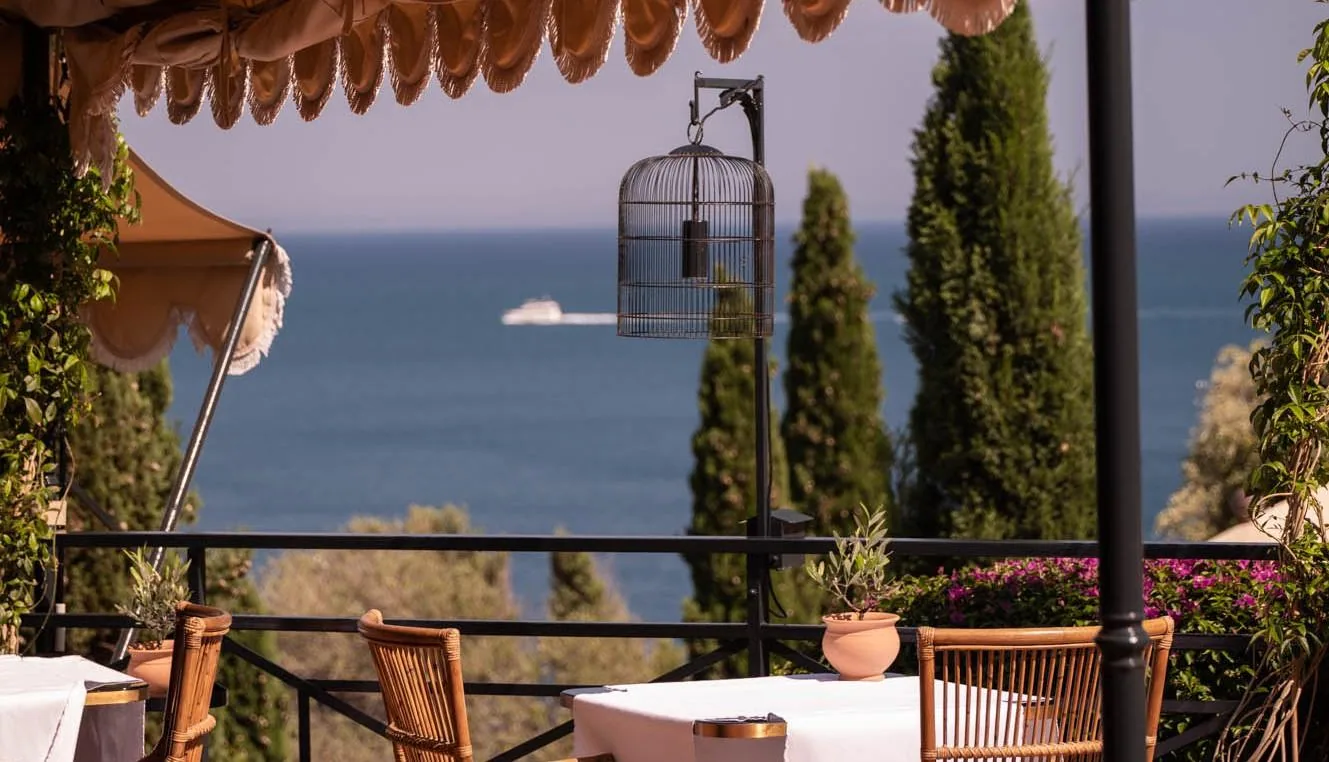 Restaurantterrasse des Il Pellicano mit weiß gedeckten Tischen und Meerblick