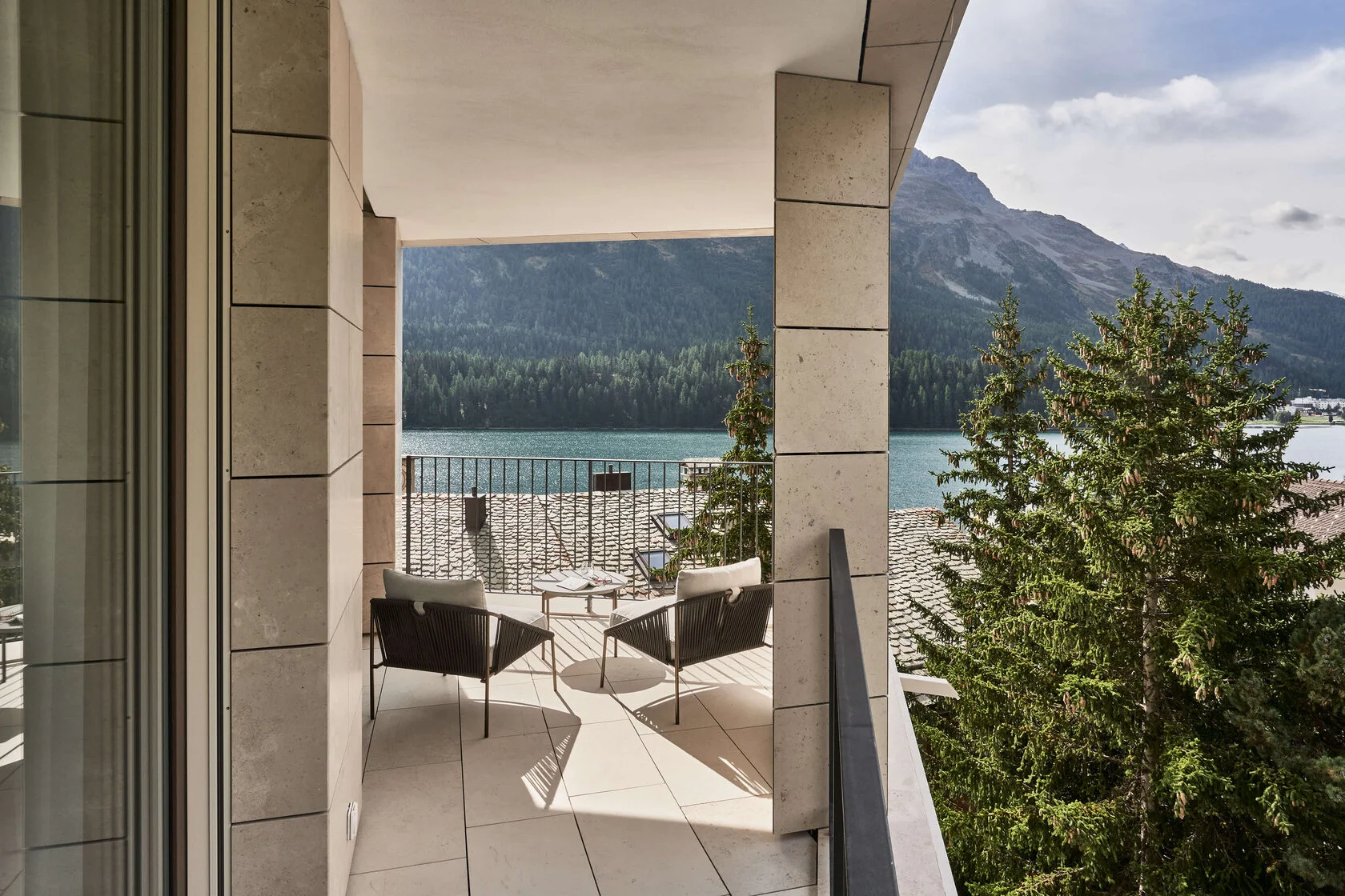 Balkon einer Suite mit Sesseln und Blick auf See und Wald