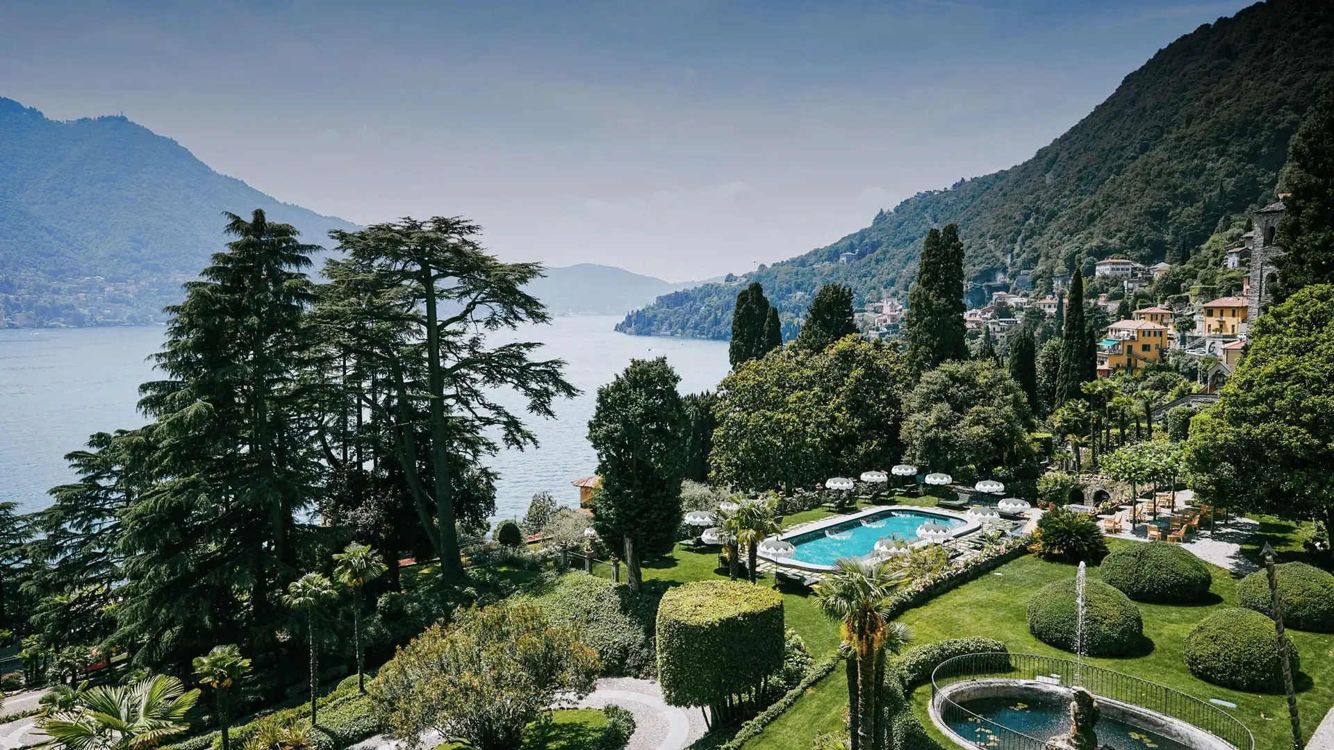 Parkanlage des Hotels mit Pool zwischen alten Bäumen