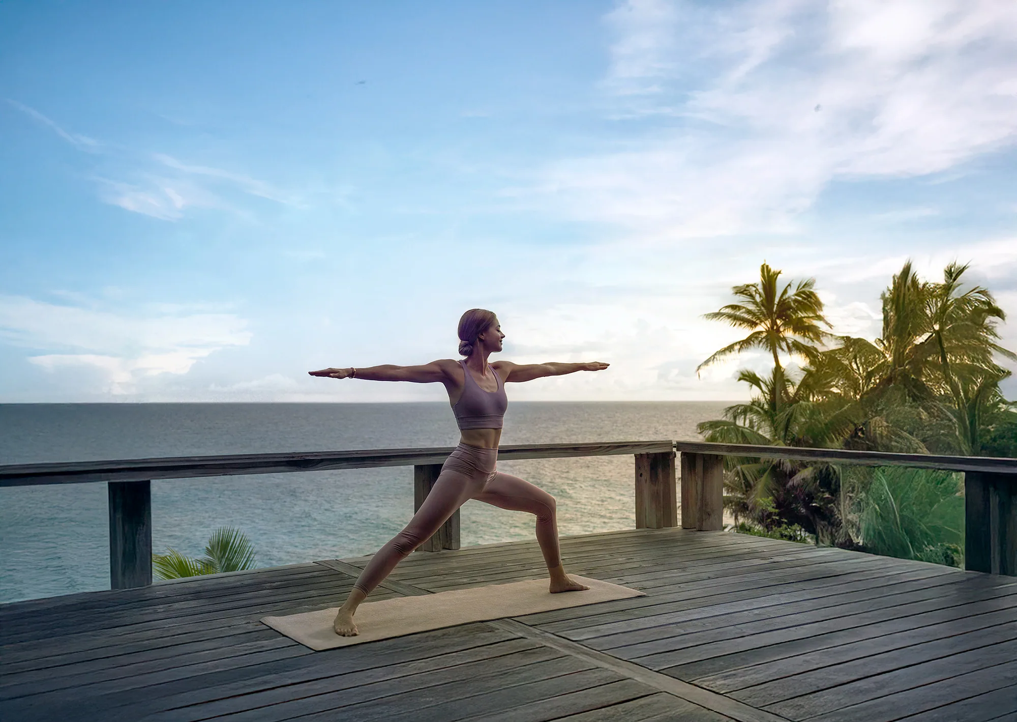 Yoga auf dem Holzdeck des Spa über dem Wasser