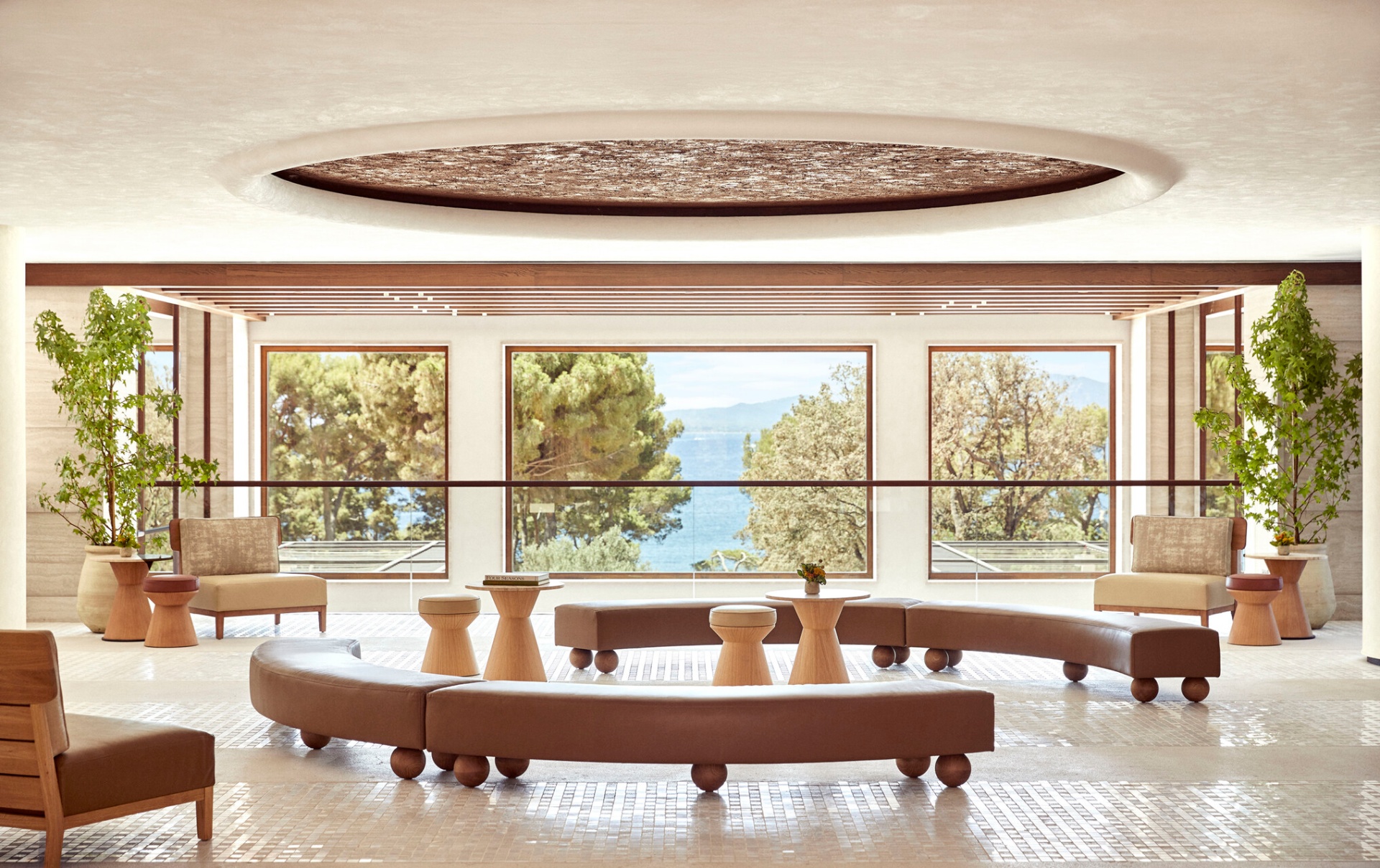 Lobby mit geschwungenen Lederbänken und Panoramafenstern zum Meer