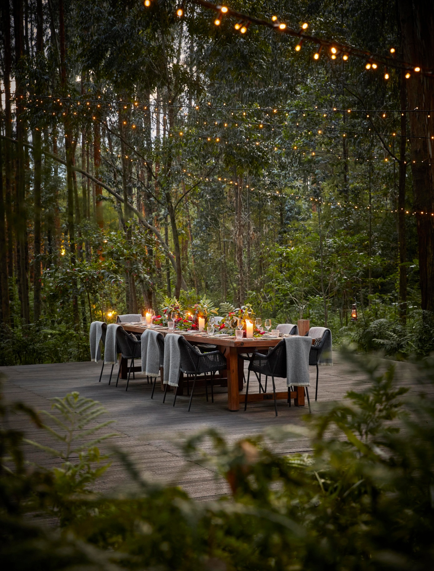 Gemütliches Frühstück neben einem Steinkamin in einer ruandischen Waldlodge mit ruandischem Kaffee in einer handgefertigten Keramiktasse, Gemüse aus dem Garten und Eukalyptuswald durch das Fenster