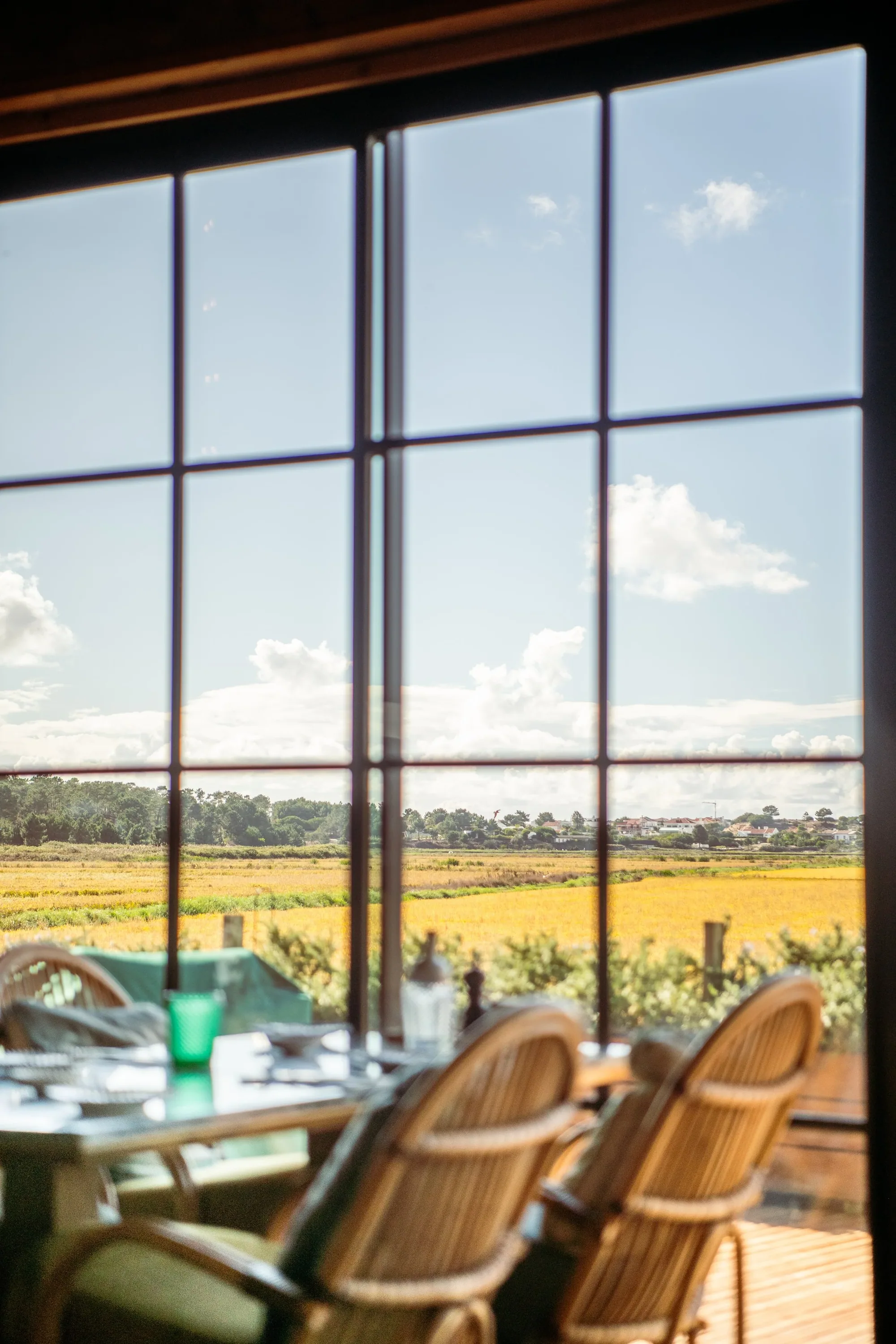 Restaurant mit langen Holztischen und offener Front zum Garten